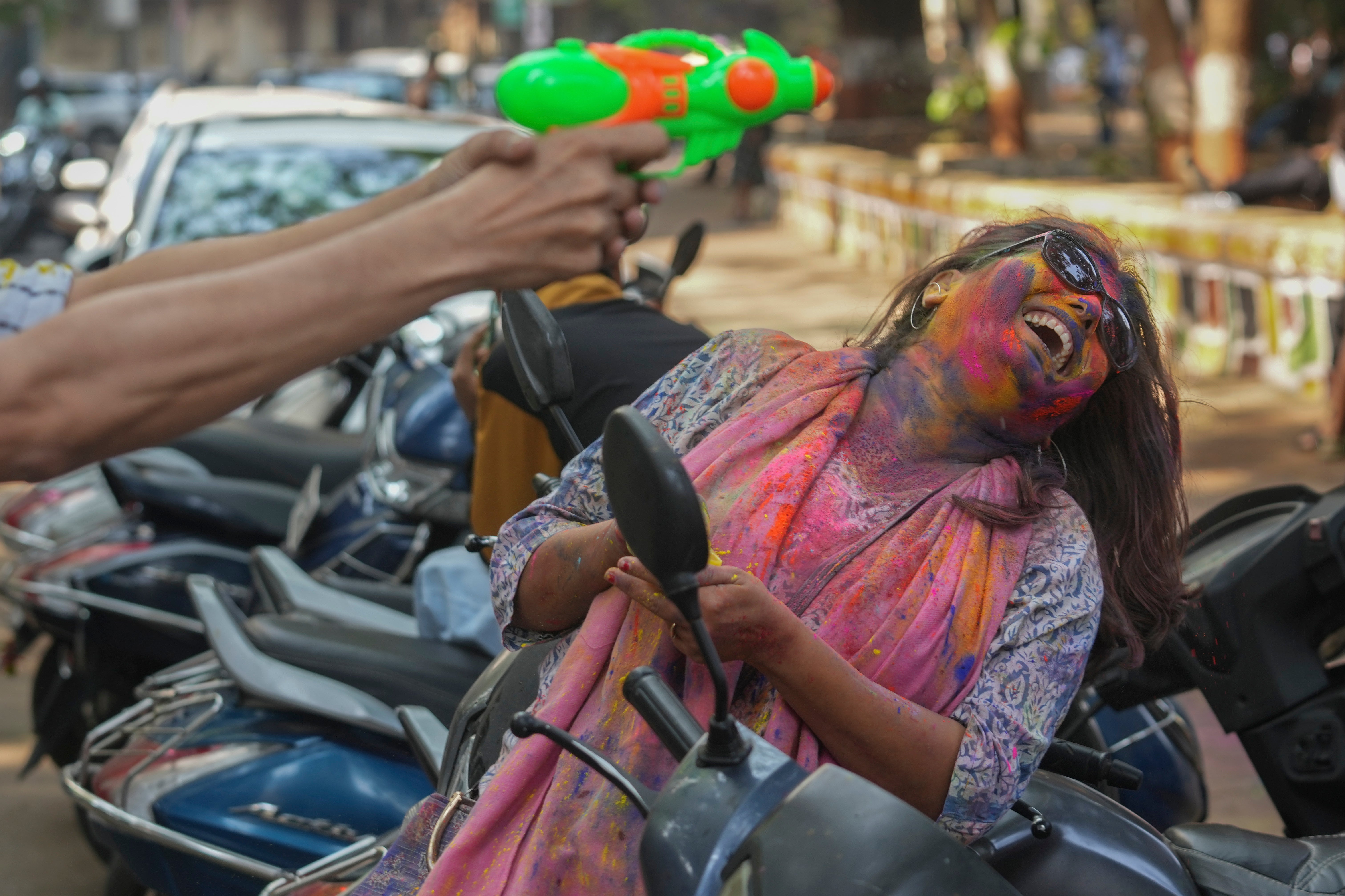 A woman with her face smeared with coloured powder celebrates Holi in Mumbai