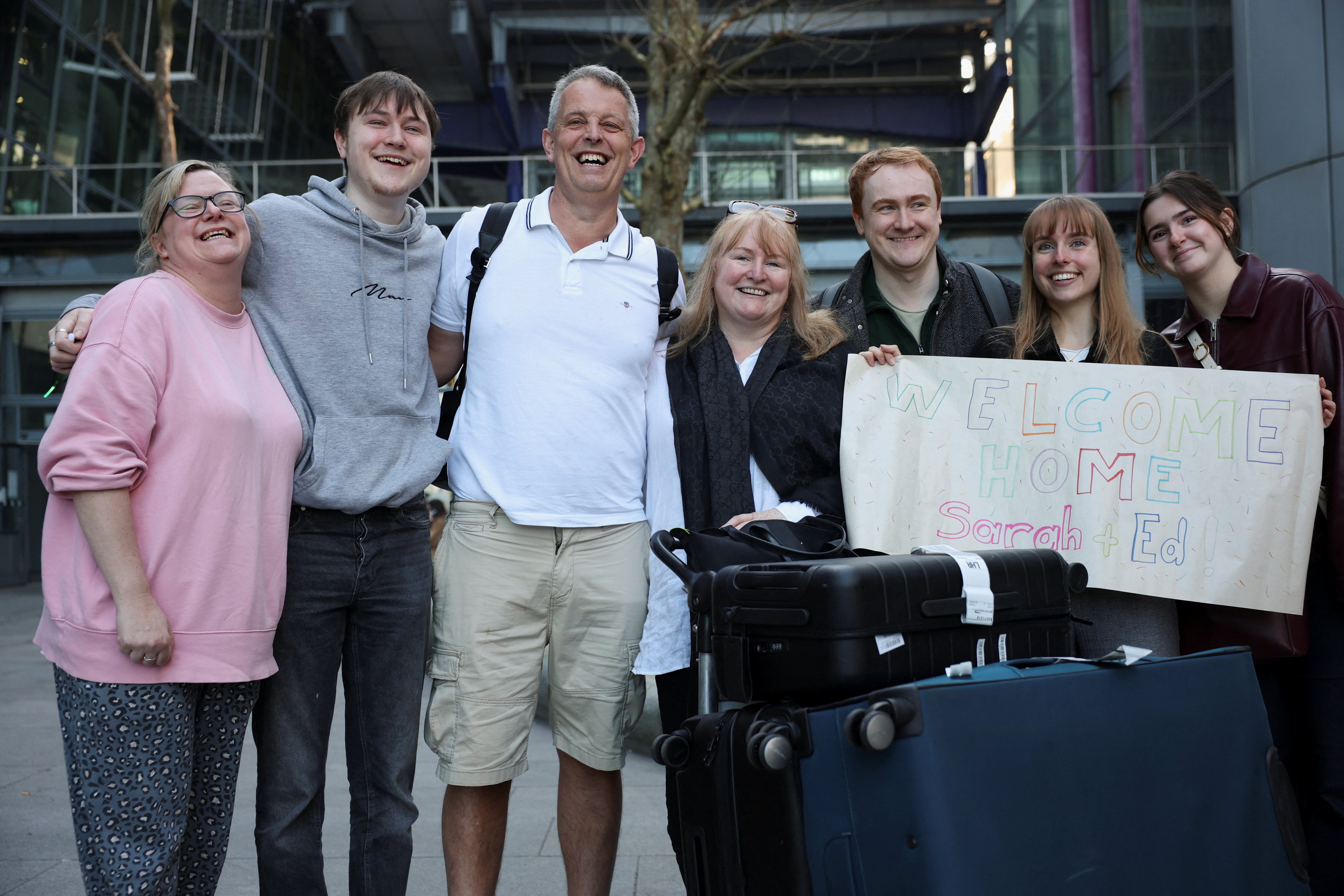 Sarah and Ed Short, passengers from a BA flight from Oman for British nationals, pose with family members, upon their arrival at Heathrow International Airport