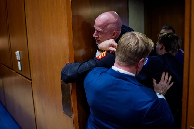 <p>El manifestante antibelicista Brian McGinnis se atasca en una puerta al ser enfrentado por la policía del Capitolio y el senador republicano Tim Sheehy, que intentaban sacarlo de una audiencia del Subcomité de Servicios Armados del Senado en el Capitolio el miércoles</p>