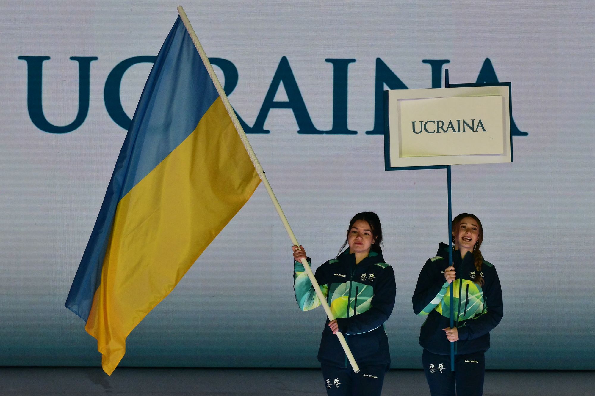 Two volunteers held the Ukrainian flag and a placard at the opening ceremony