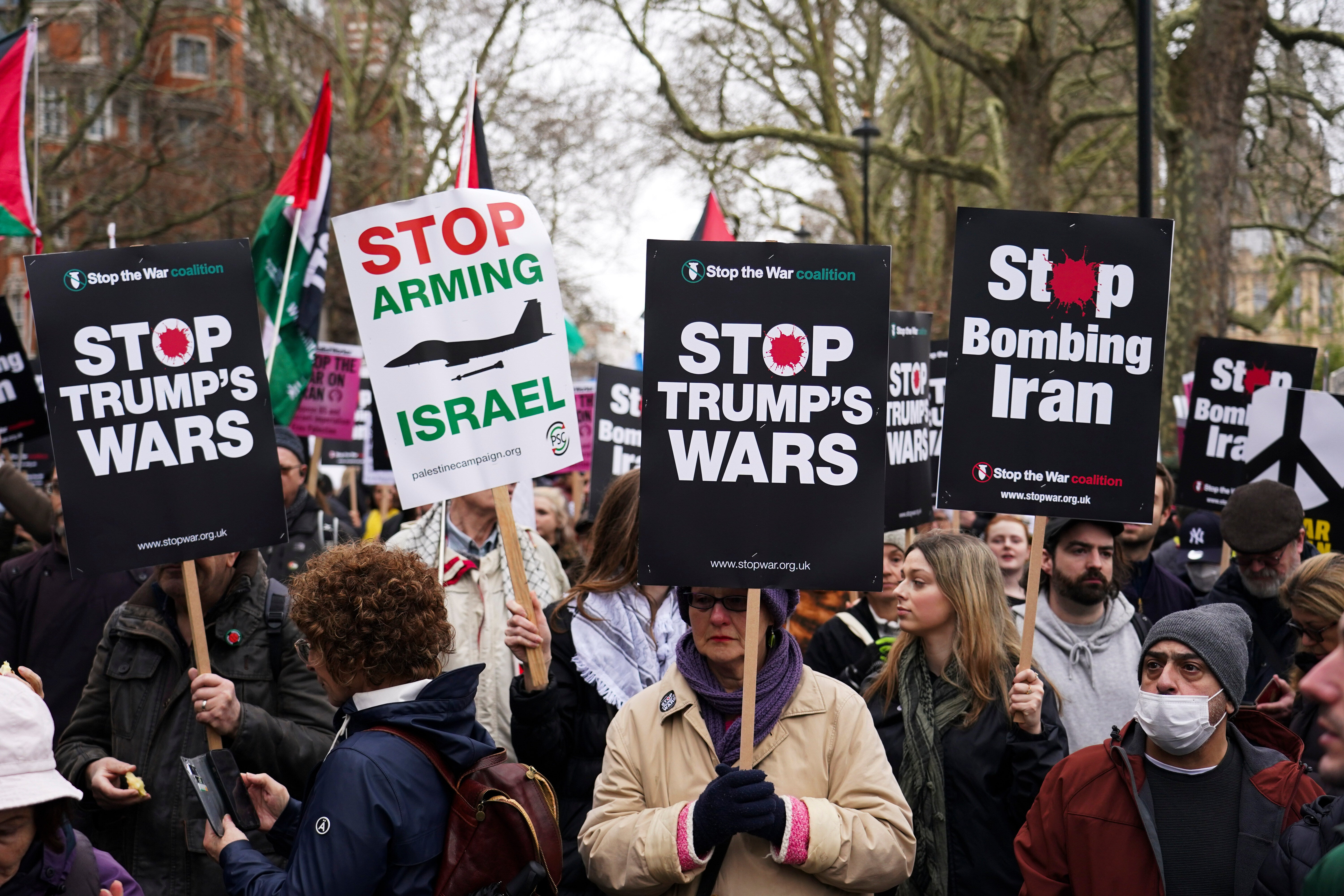 Demonstrators hold flags and placards as they attend a Stop the War Coalition march in London