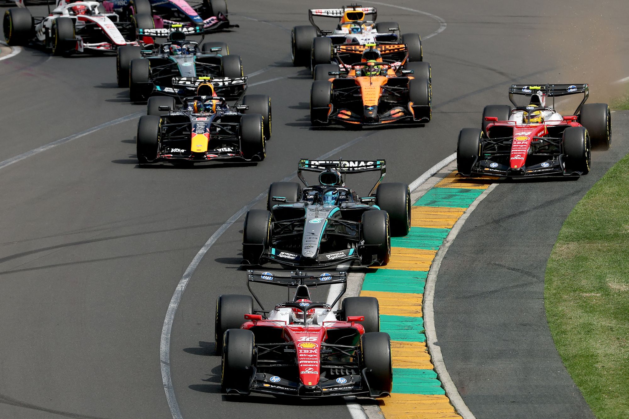 Ferrari's Monegasque driver Charles Leclerc leads the pack at the start of the Formula One Australian Grand Prix