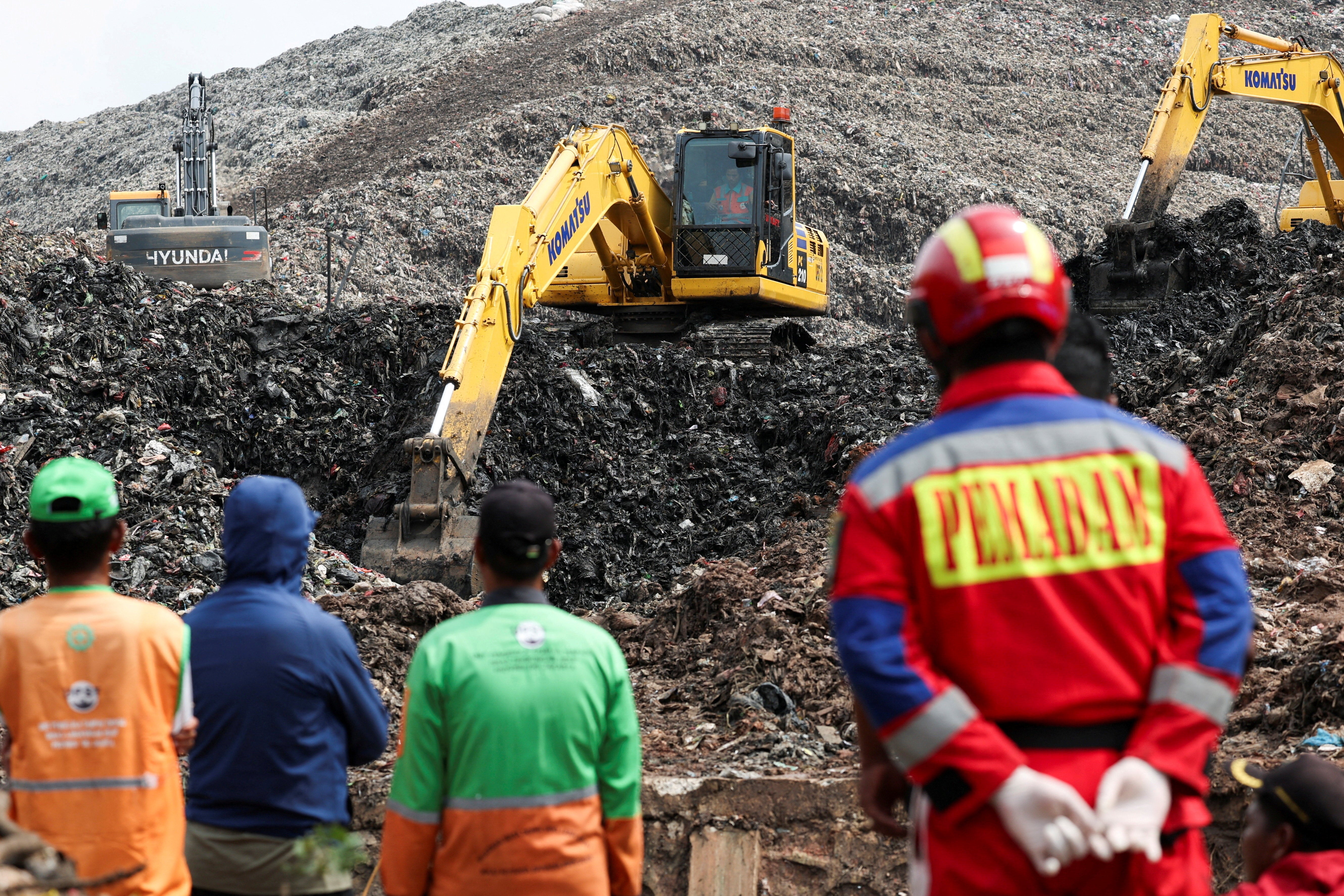 Excavators operate at the site of a collapse at Bantar Gebang landfill during a rescue operation in Bekasi, on the outskirts of Jakarta, Indonesia