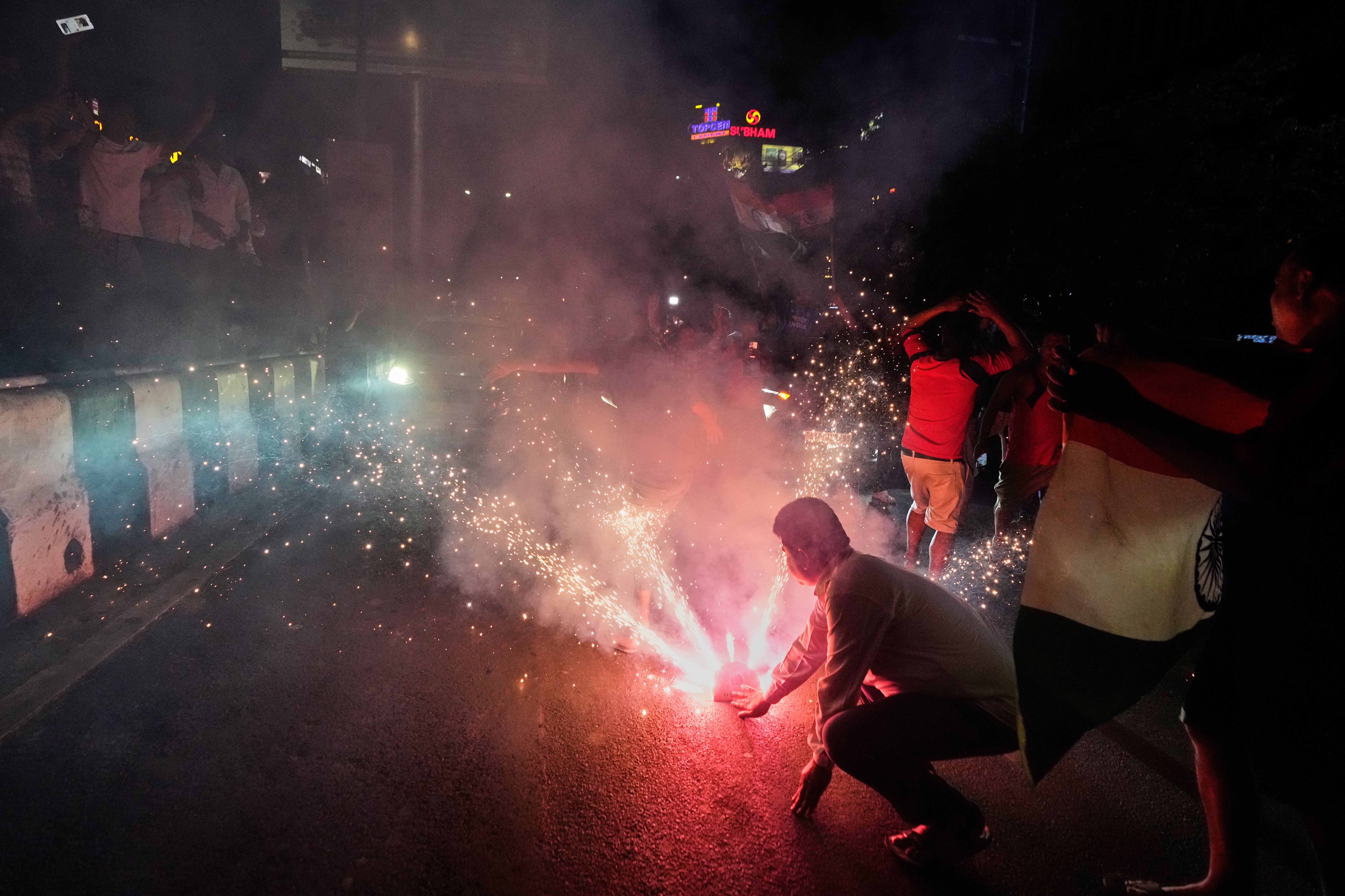 Cricket fans celebrate on a road after India defeated New Zealand in the final match of the T20 World Cup in Guwahati, India