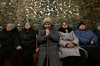 Local women gather at an aid and support centre to get humanitarian aid distributed by volunteers on the occasion of the International Women's Day, in the settlement of Velyka Novosilka