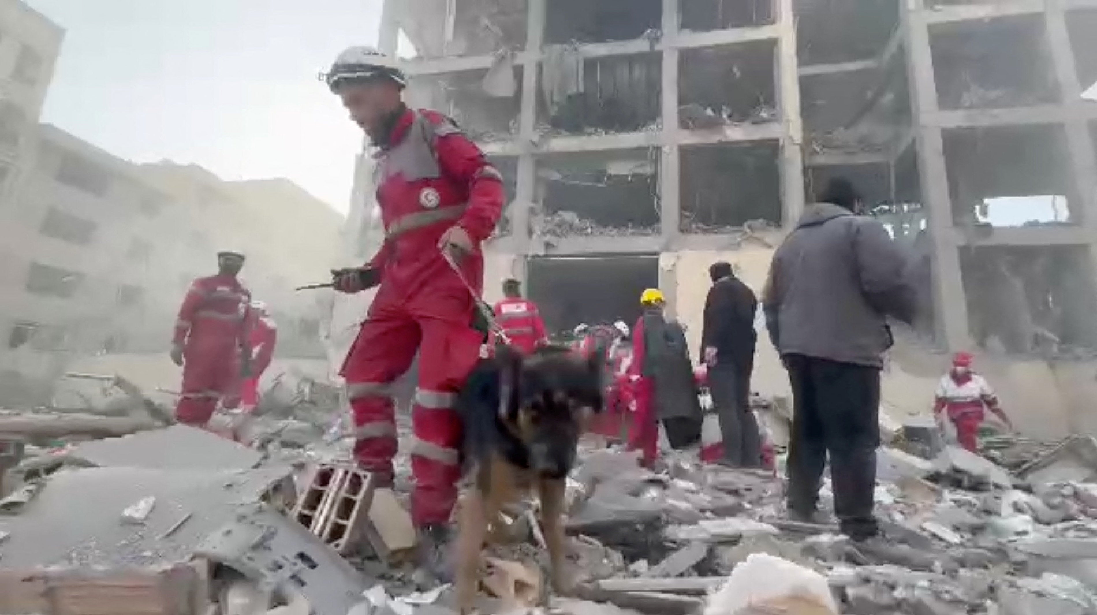 Rescuers work through the rubble of residential buildings after airstrikes in Tehran's Resalat district