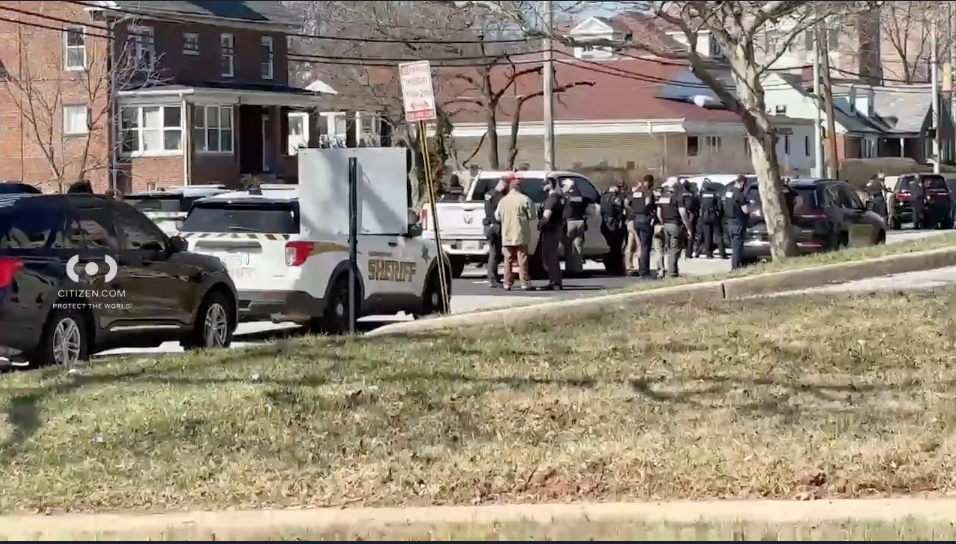 Several police vehicles and officers seen in a city street