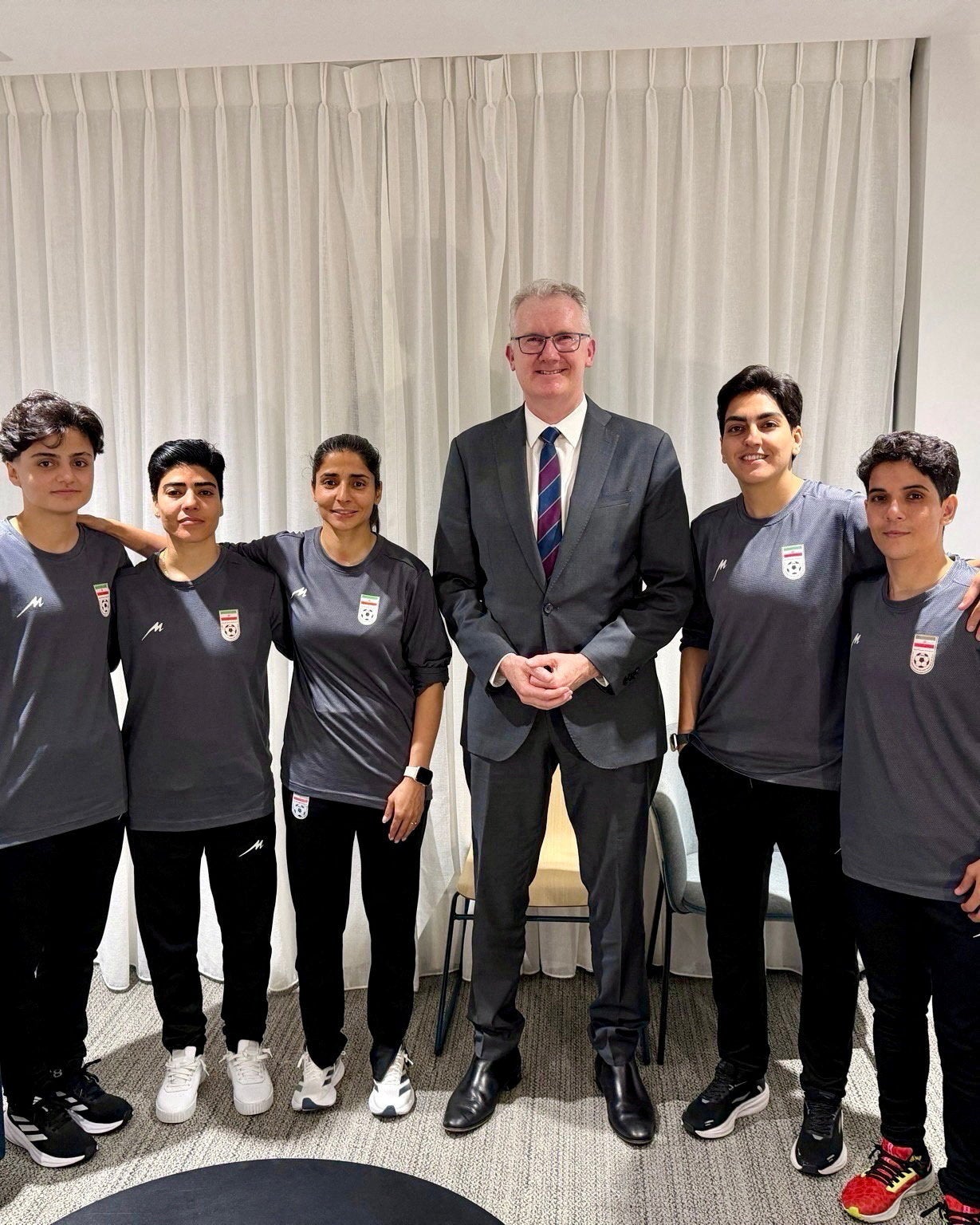 Australia's Home Affairs Minister Tony Burke poses with Fatemeh Pasandideh, Mona Hamoudi, Atefeh Ramezanizadeh, Zahra Ghanbari and Zahra Sarbali