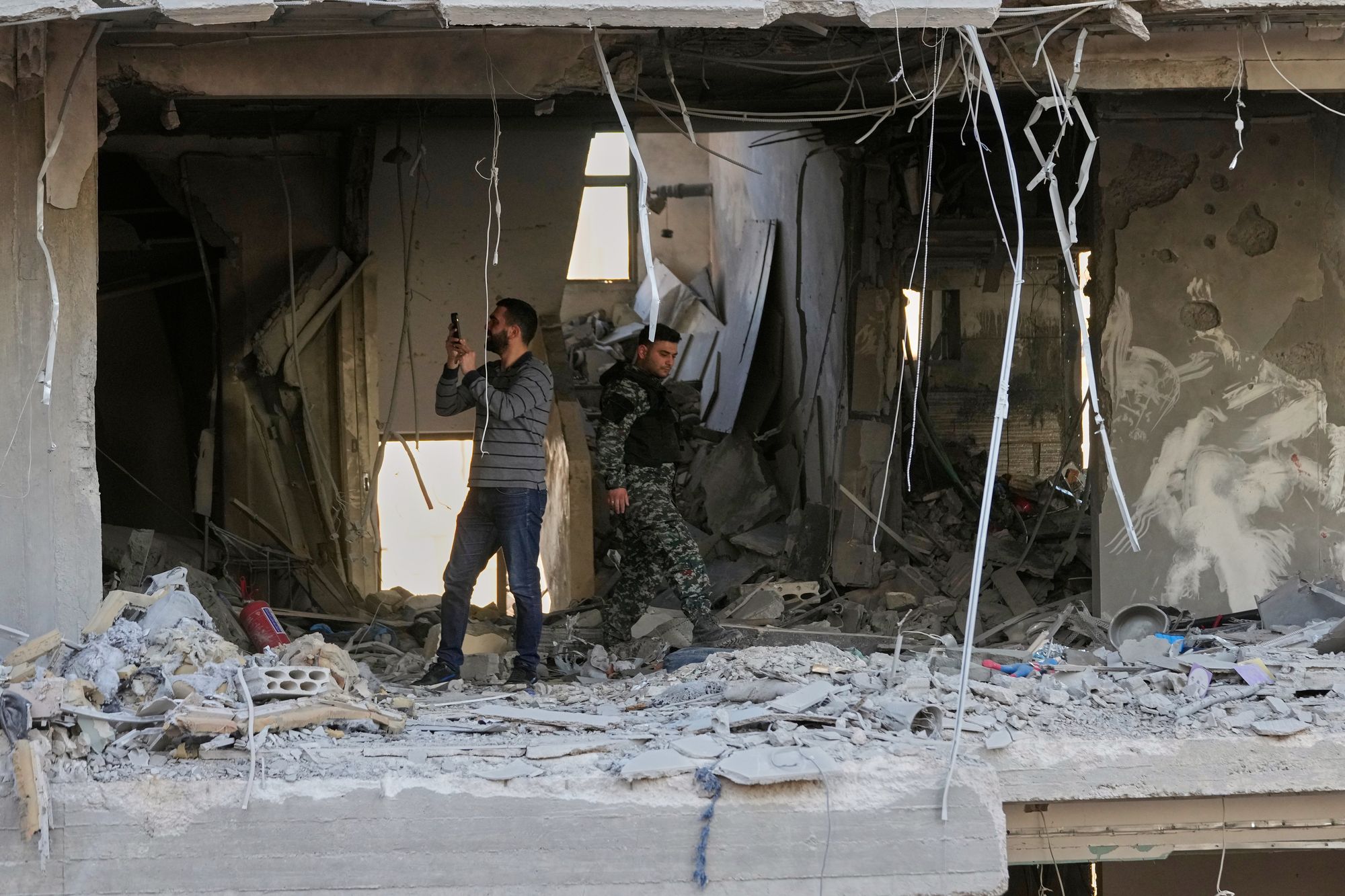 Security officers check a destroyed apartment at a residential building that was hit by an Israeli airstrike in Beirut, Lebanon