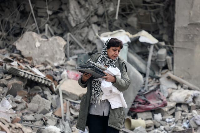 <p>Una mujer iraní recoge sus pertenencias entre los escombros de un edificio residencial destruido en Teherán, el 12 de marzo de 2026</p>