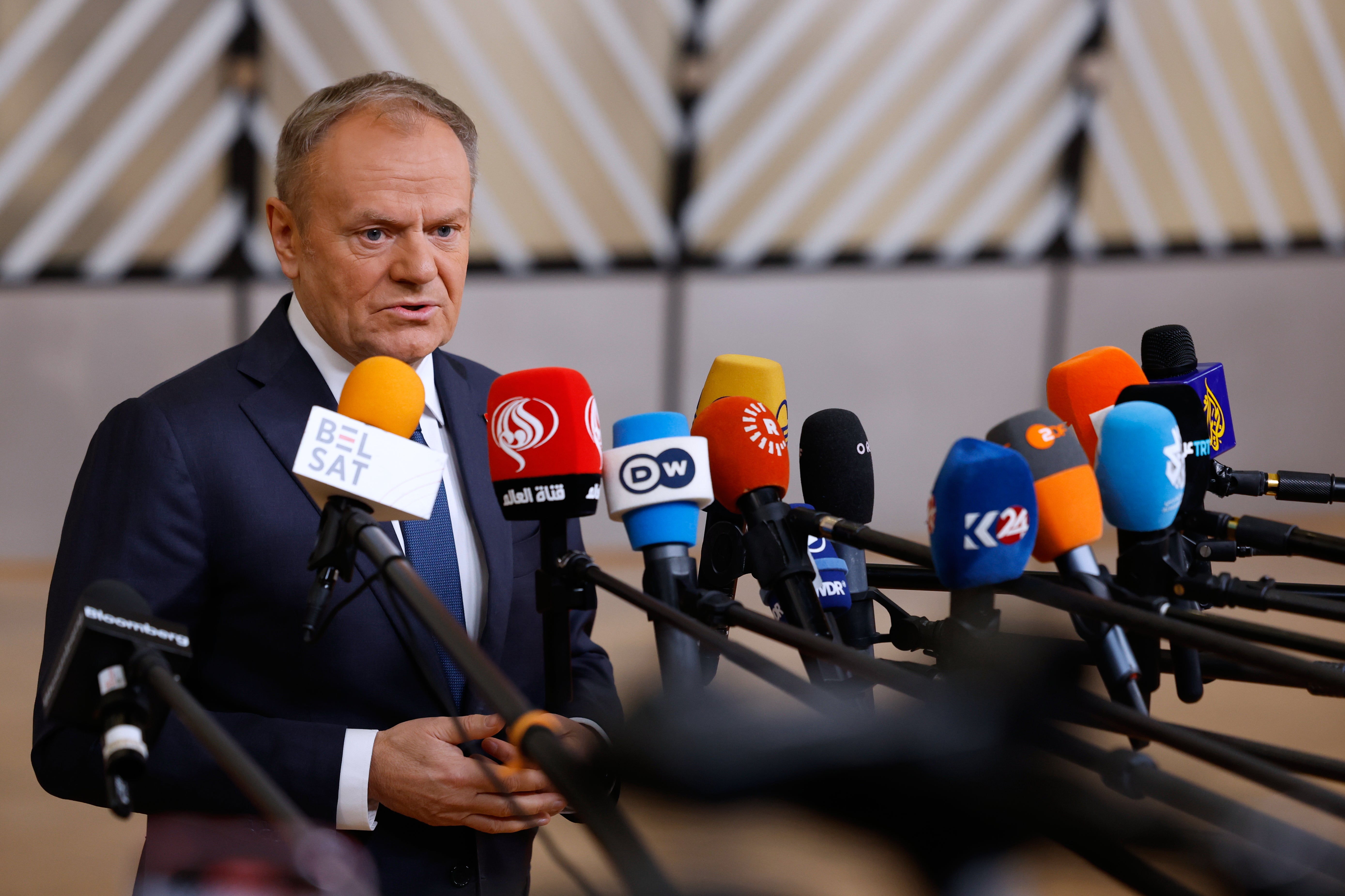 Polish PM Donald Tusk speaks with the media as he arrives for the EU summit in Brussels