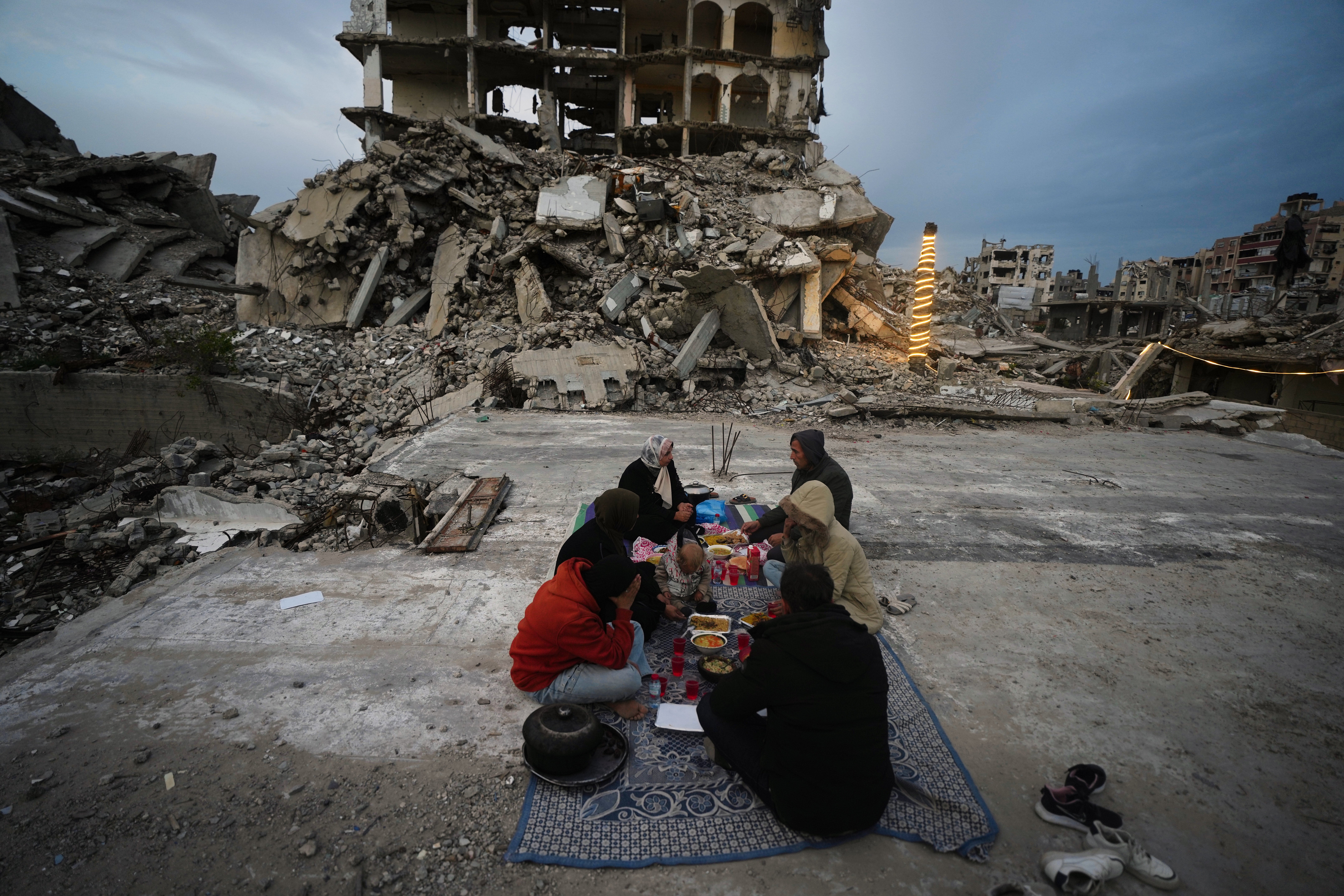 Members of the Al-Najar family break their fast during the Muslim holy month of Ramadan amid the rubble of destroyed buildings in Gaza City Friday, March 13, 2026.