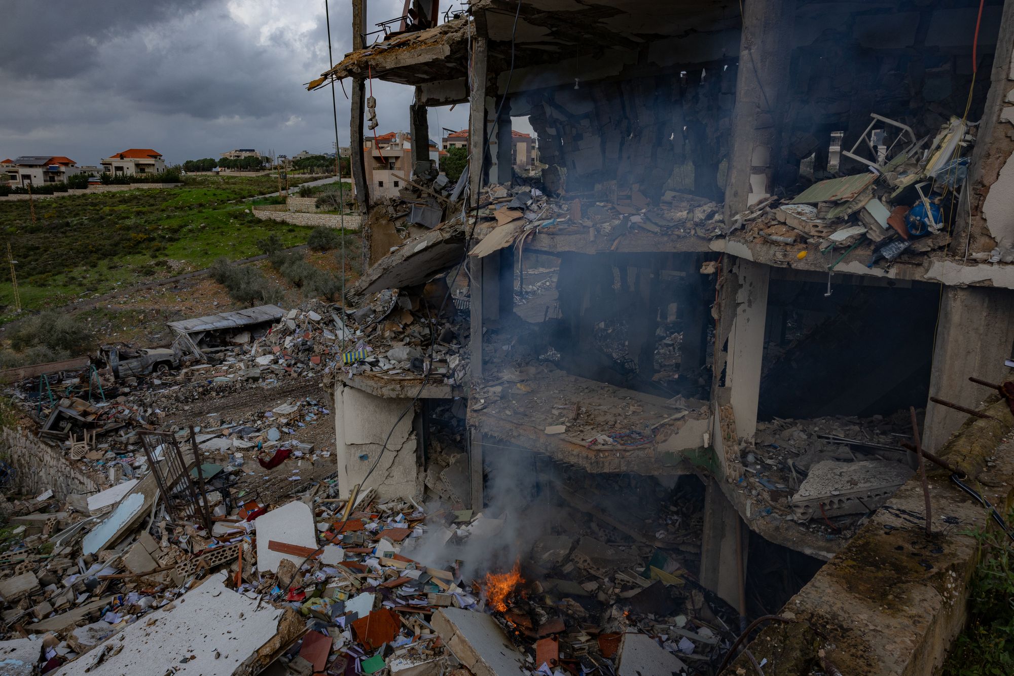 Fires still burn by the destroyed building in South Lebanon