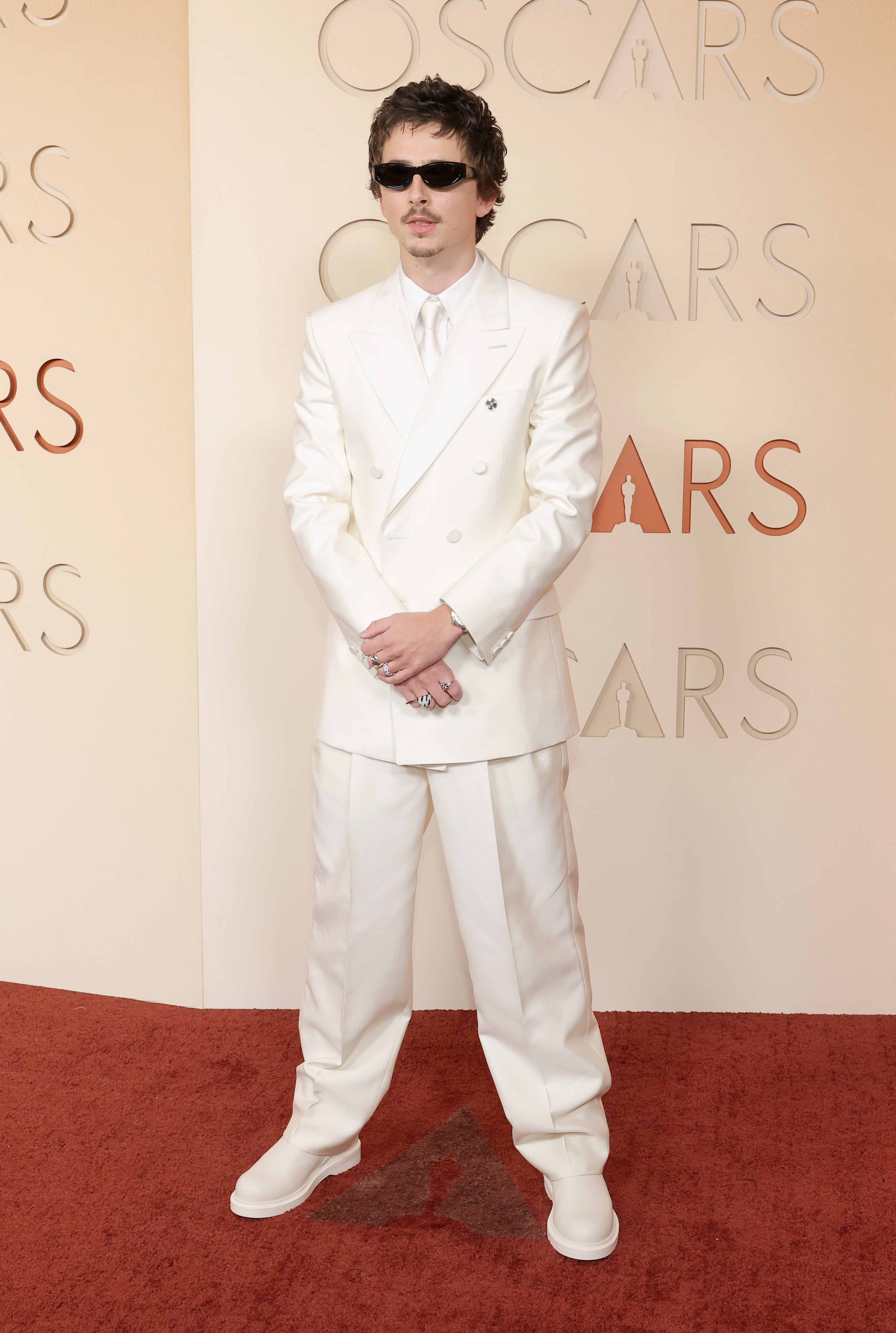 The ‘Marty Supreme’ actor otherwise stunned on the red carpet in his all-white suit, until he randomly threw on a pair of black sunglasses and power-posed for a photo