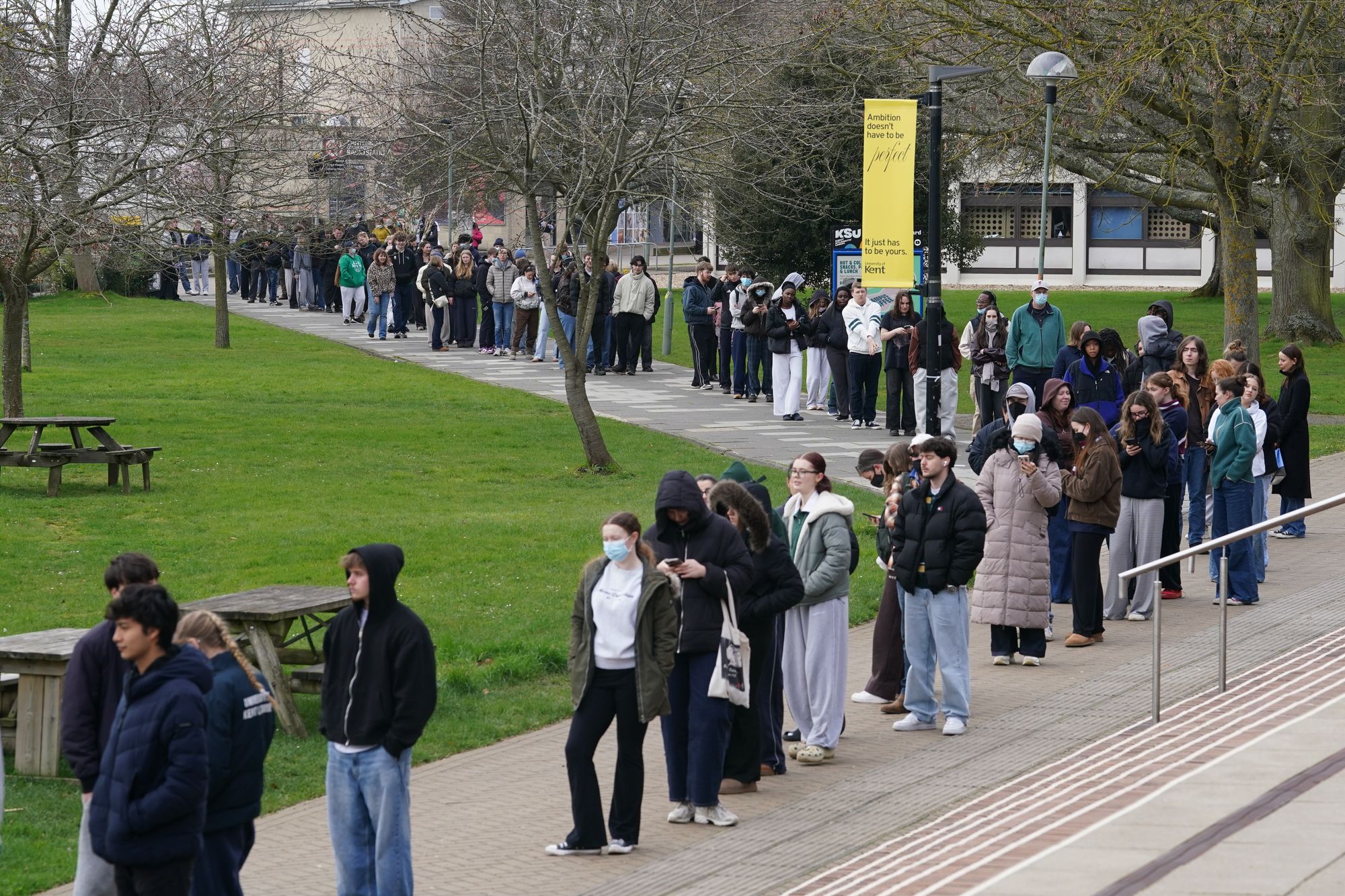 Students queuing for antibiotics outside a building at the University of Kent in Canterbury on Monday