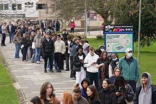 Students queue for antibiotics outside a building at the University of Kent in Canterbury on Monday.