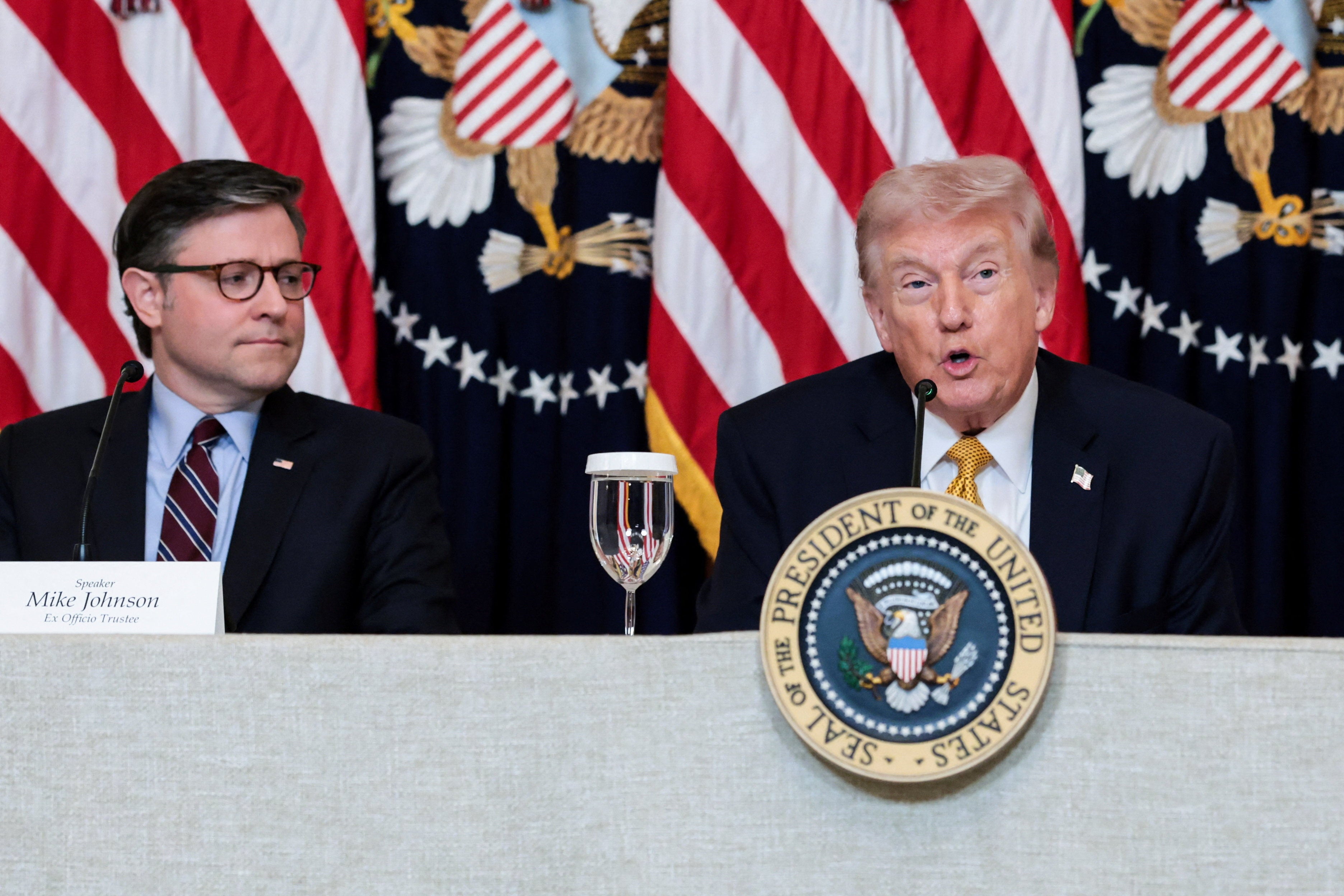 U.S. Speaker of the House Mike Johnson (R-LA) listens to U.S. President Donald Trump speaking during a lunch with the Kennedy Center board members in the East Room of the White House in Washington, D.C., U.S., March 16, 2026. REUTERS/Jonathan Ernst