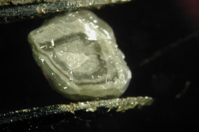 <p> Primer plano de un diamante sobre un fondo negro y gris </p>