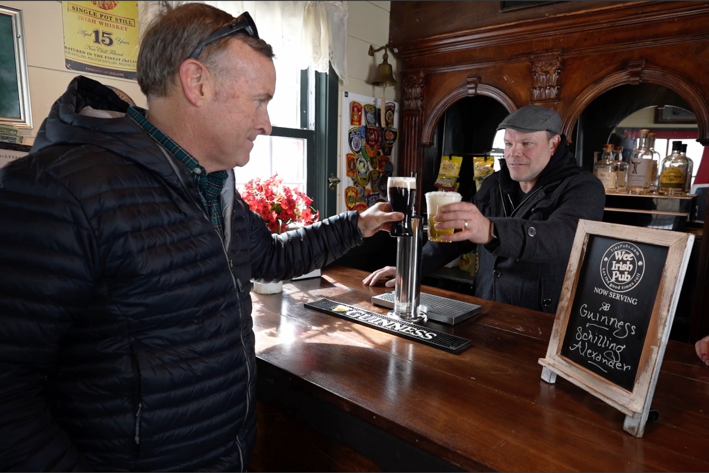 Mark Cote, left, toasts Matt Taylor after receiving delivery of a rented tiny pub for an early St. Patrick's Day party, Friday, March 13, 2026, in Andover, Mass. (AP Photo/Robert F. Bukaty)