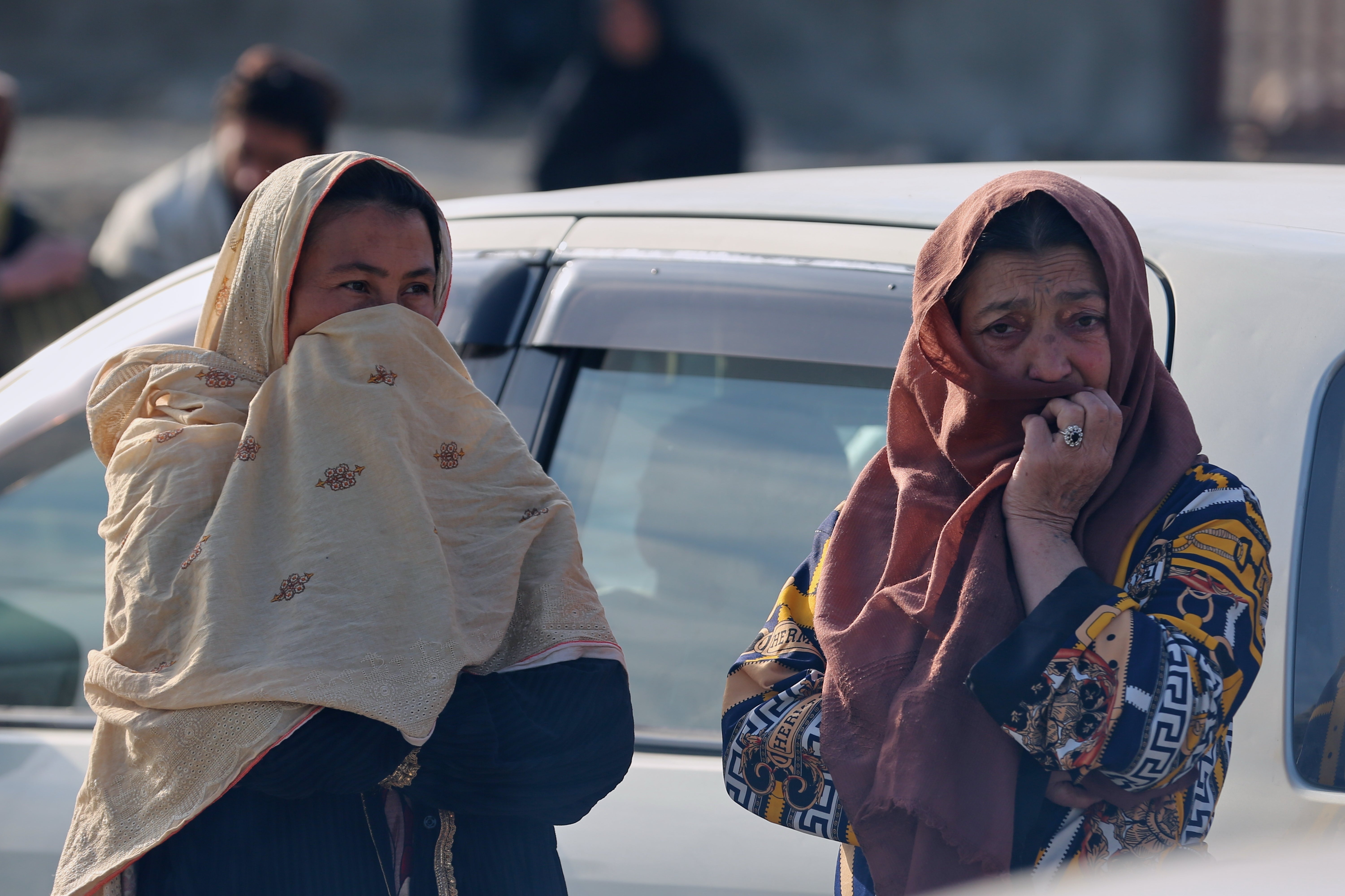 Two women watch as rescue workers and officials inspect the site of a late-Monday airstrike at a drug rehabilitation hospital in Kabul, Afghanistan, Tuesday, March 17, 2026. (AP Photo/Siddiqullah Alizai)