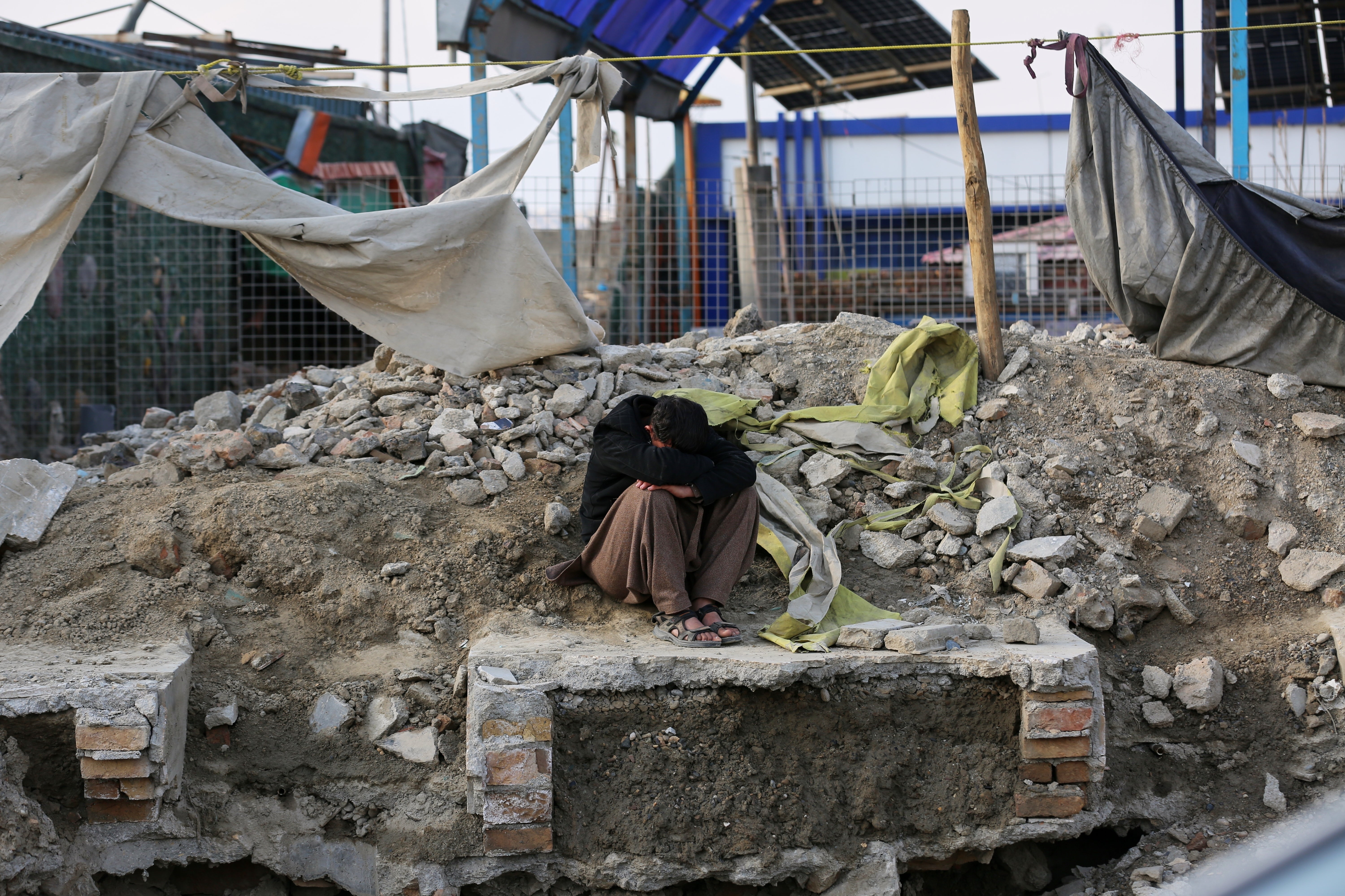 A man sits beside the site of a late-Monday airstrike at a drug rehabilitation hospital in Kabul, Afghanistan, Tuesday, March 17, 2026. (AP Photo/Siddiqullah Alizai)