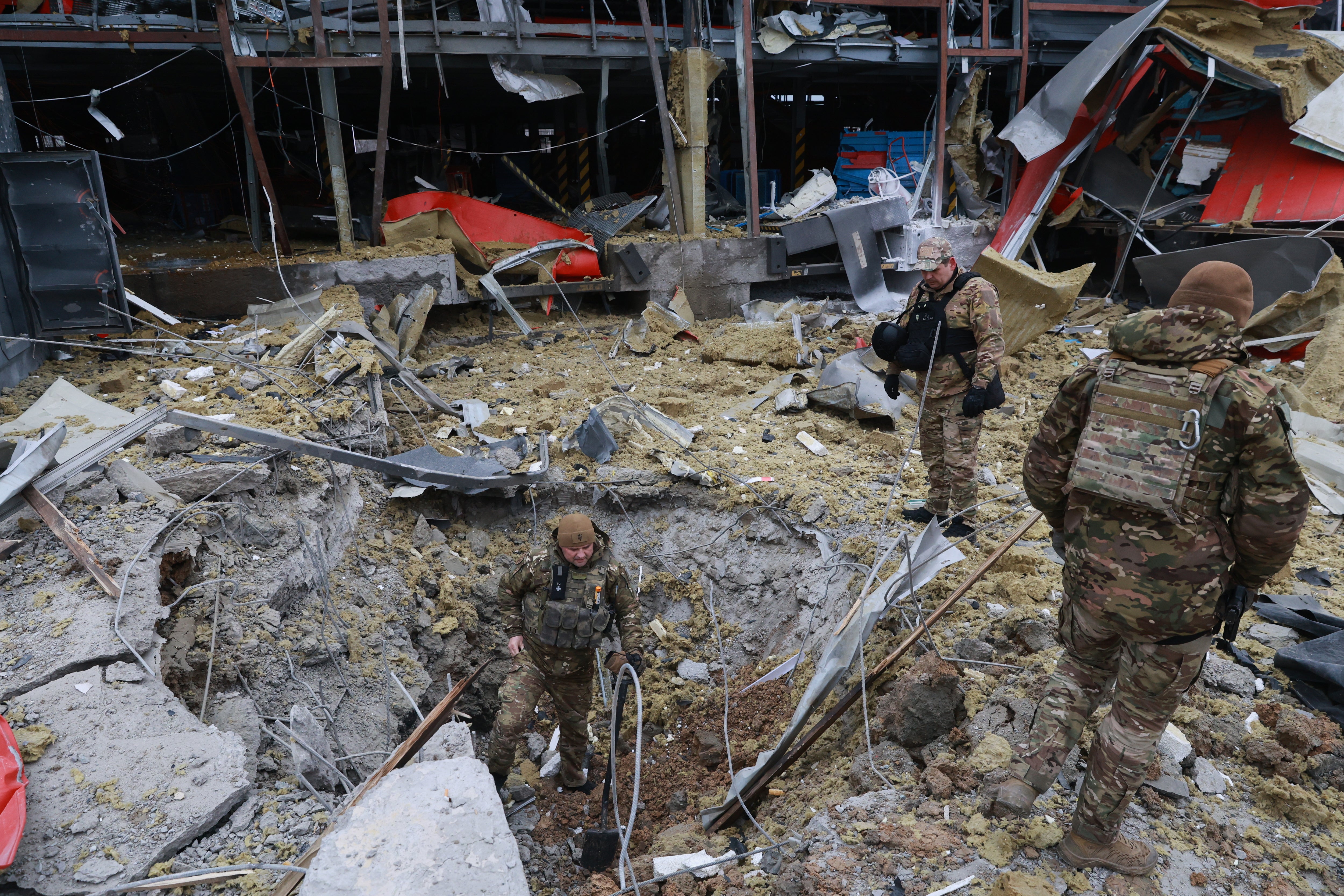 Sappers examine the site of a Russian missile strike which hit a post office storehouse in Zaporizhzhia, Ukraine, Tuesday, 17 March