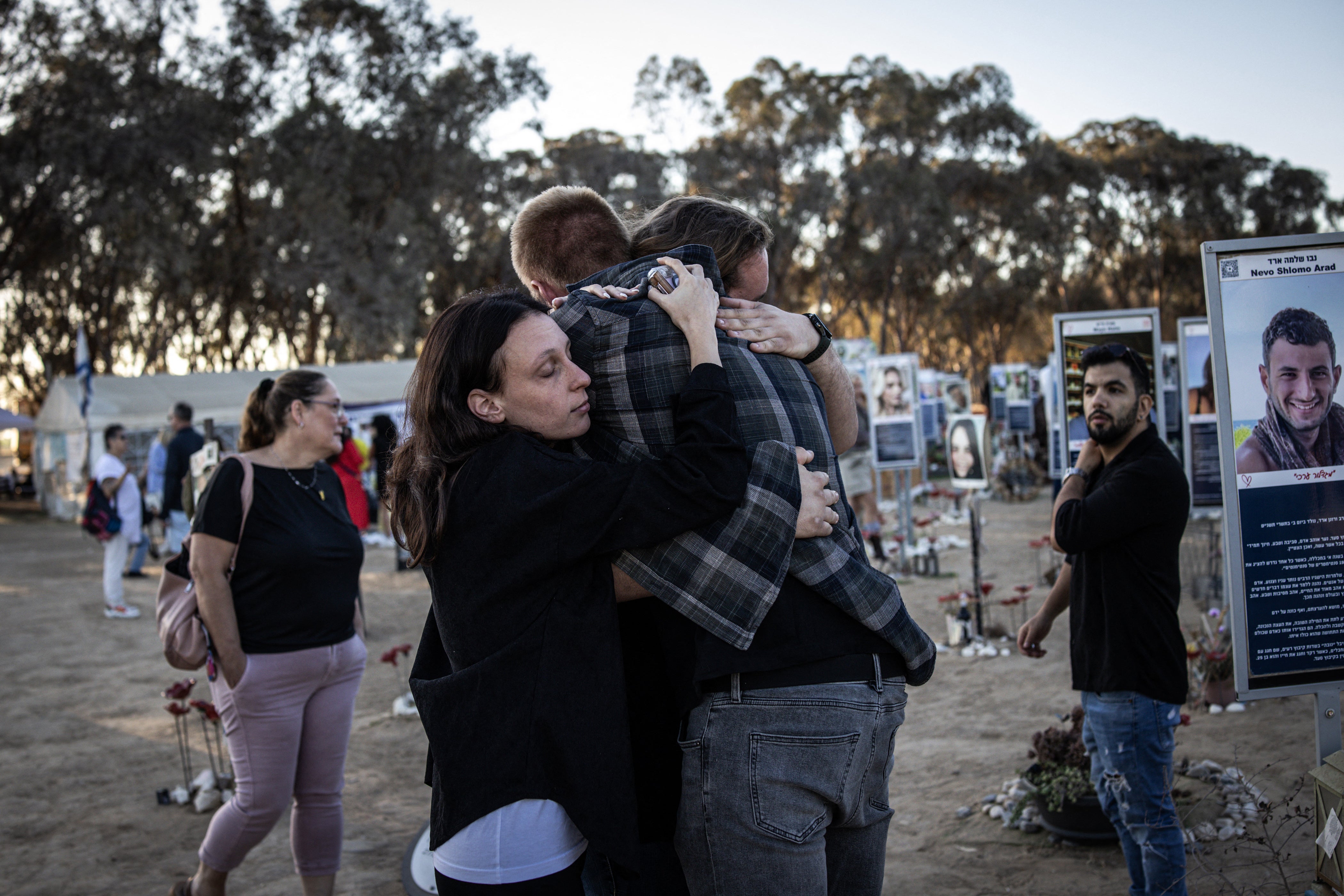 People embrace next to monuments to the victims of the October 7, 2023 attacks at the Nova Festival site in the southern Israeli city of Reim