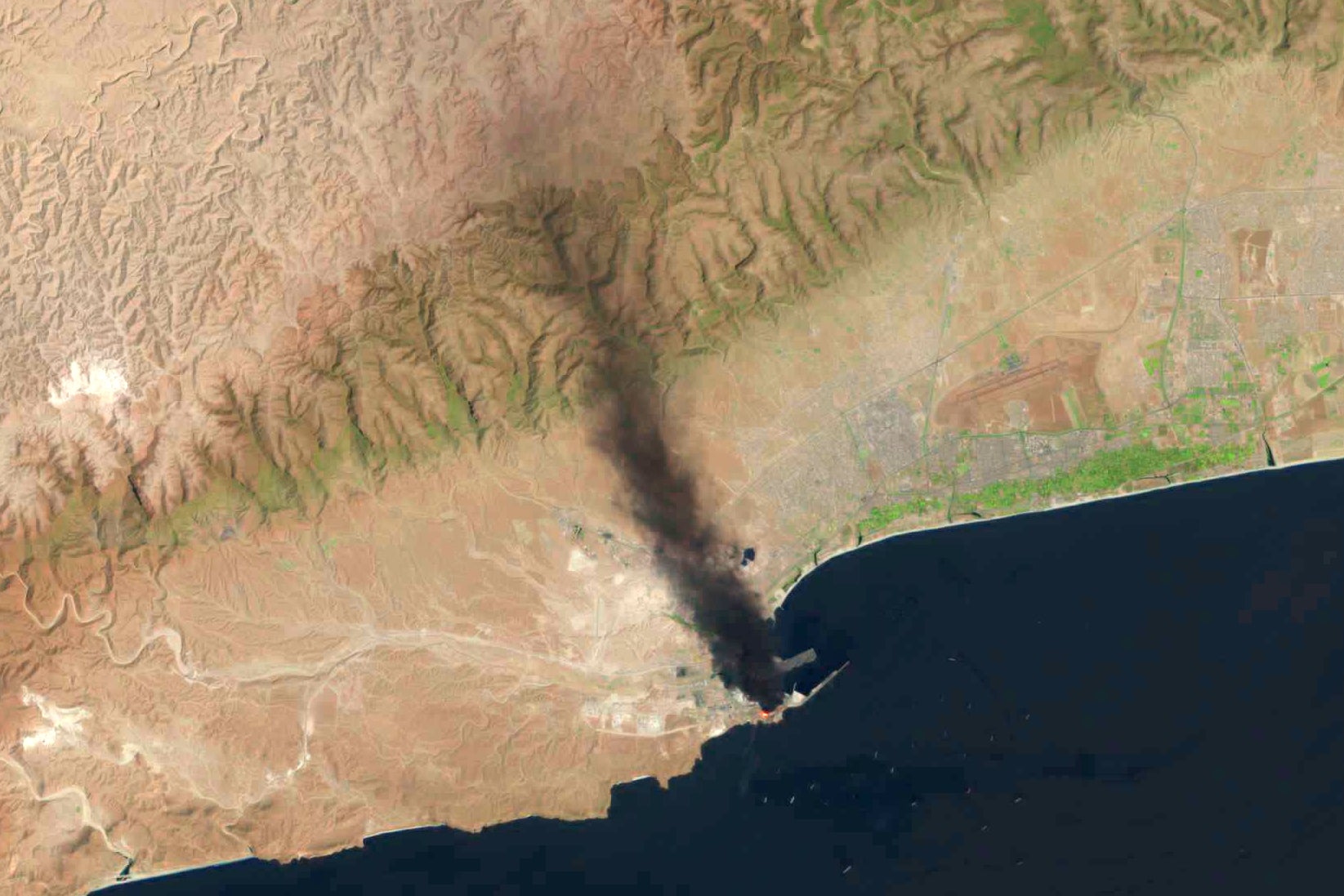A fire burns days after a suspected Iranian attack targeting the port in Salalah, Oman, Monday, March 16, 2026