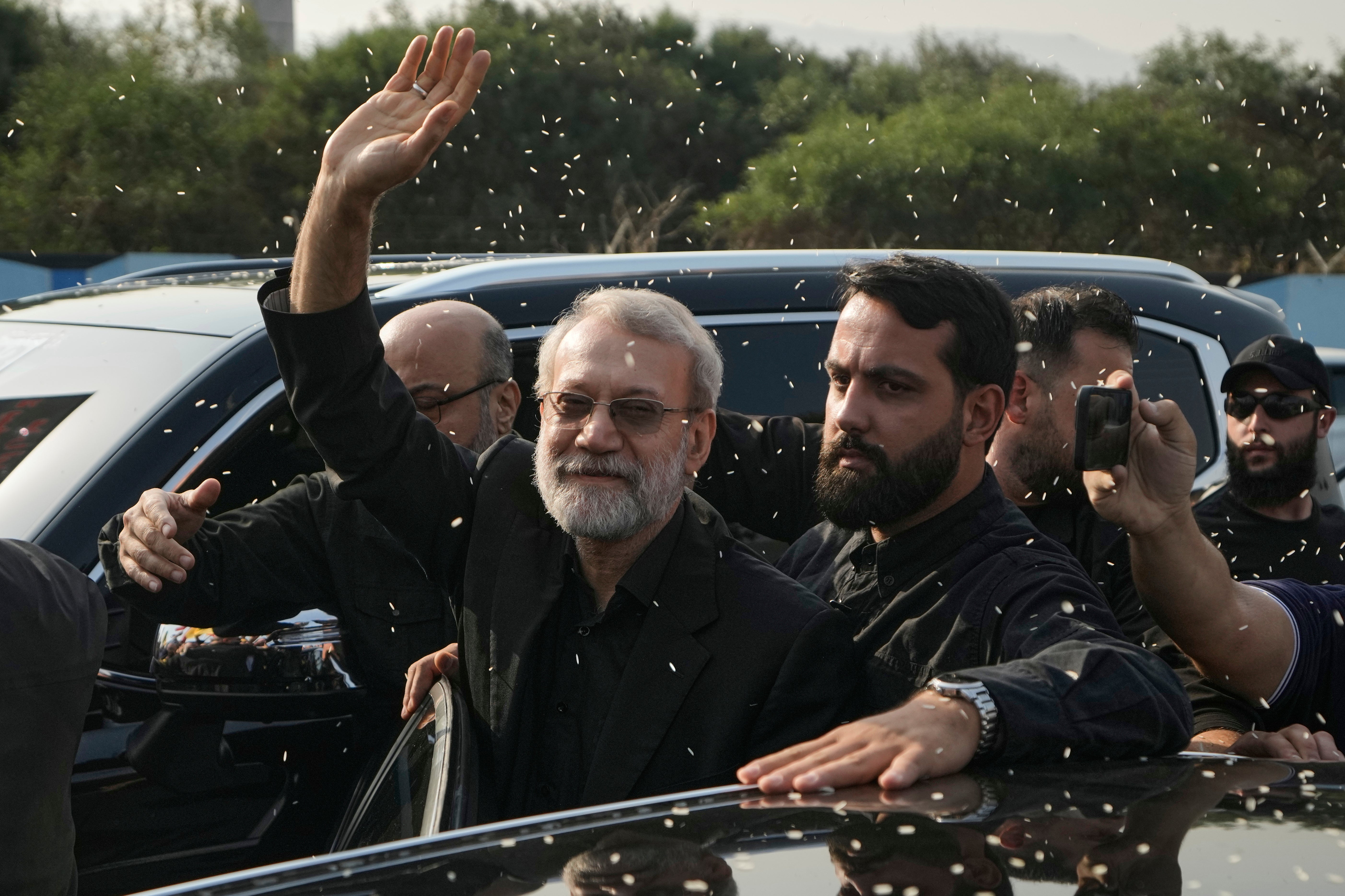 Ali Larijani, head of Iran’s National Security Council, gestures as Hezbollah supporters throw rice to welcome him outside Rafik Hariri International Airport in Beirut, Lebanon