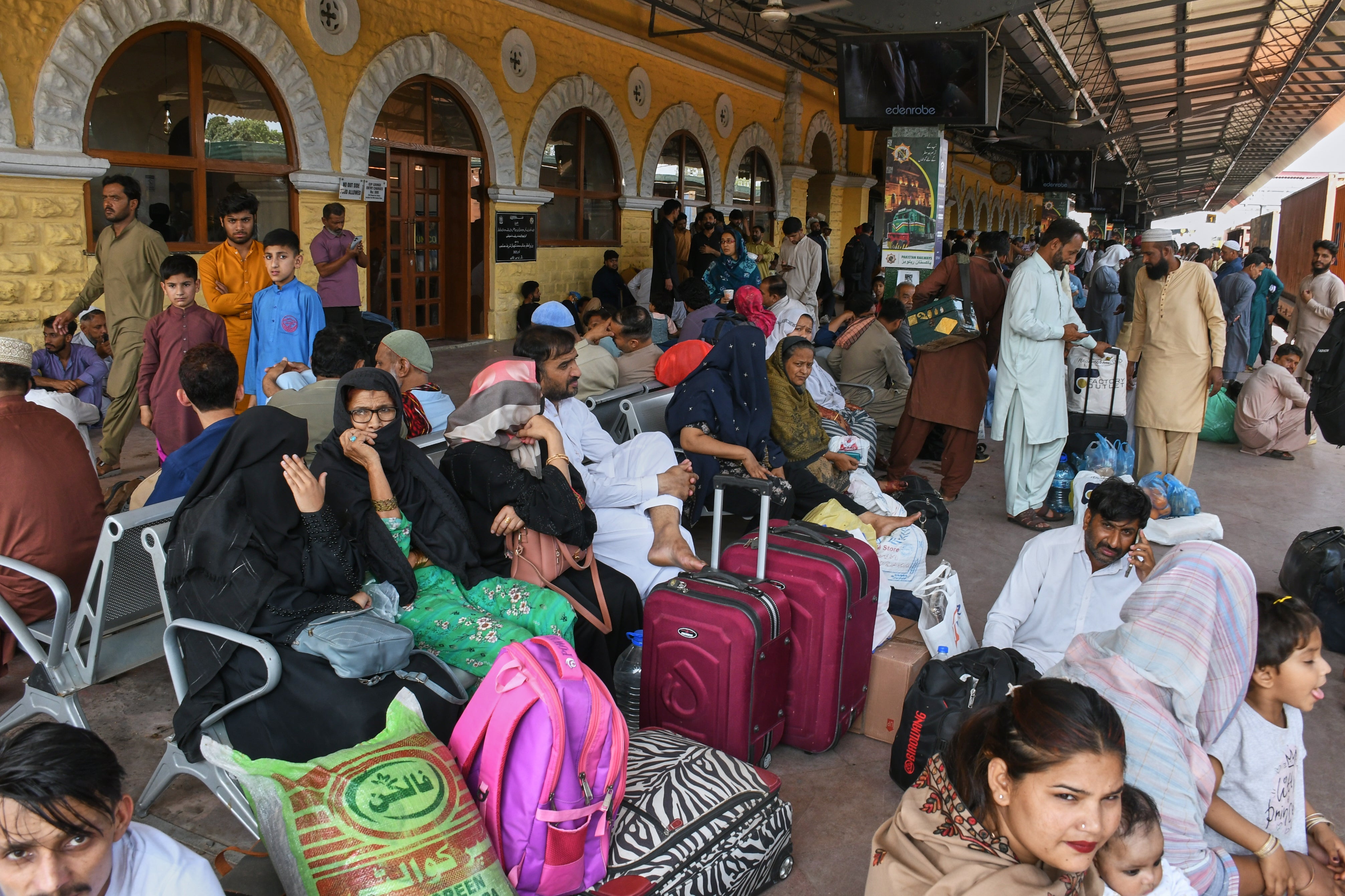 People wait to board passenger train to return home to celebrate the upcoming Eid al-Fitr holidays