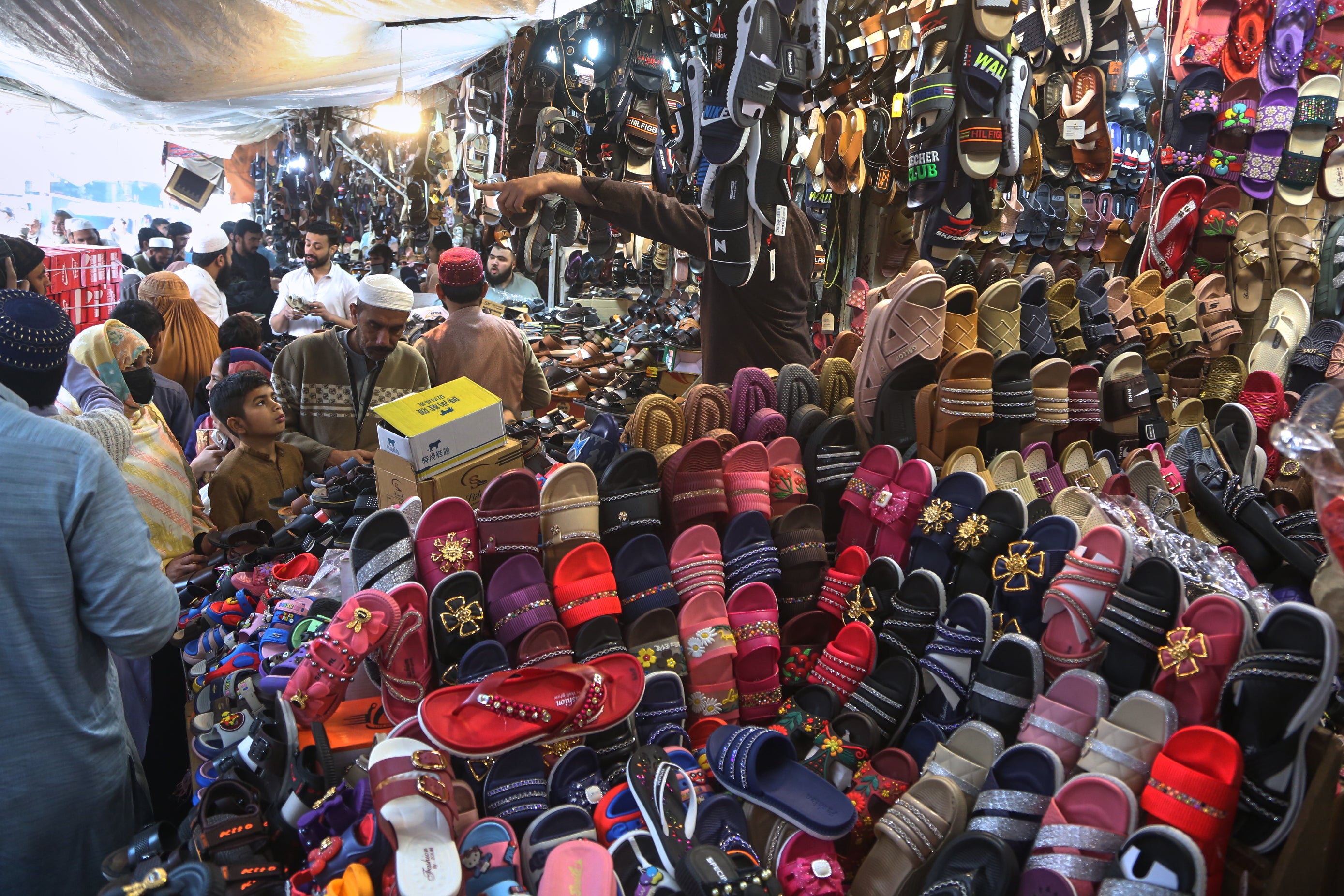 A family browses footwear at a local market for the upcoming Eid al-Fitr celebrations