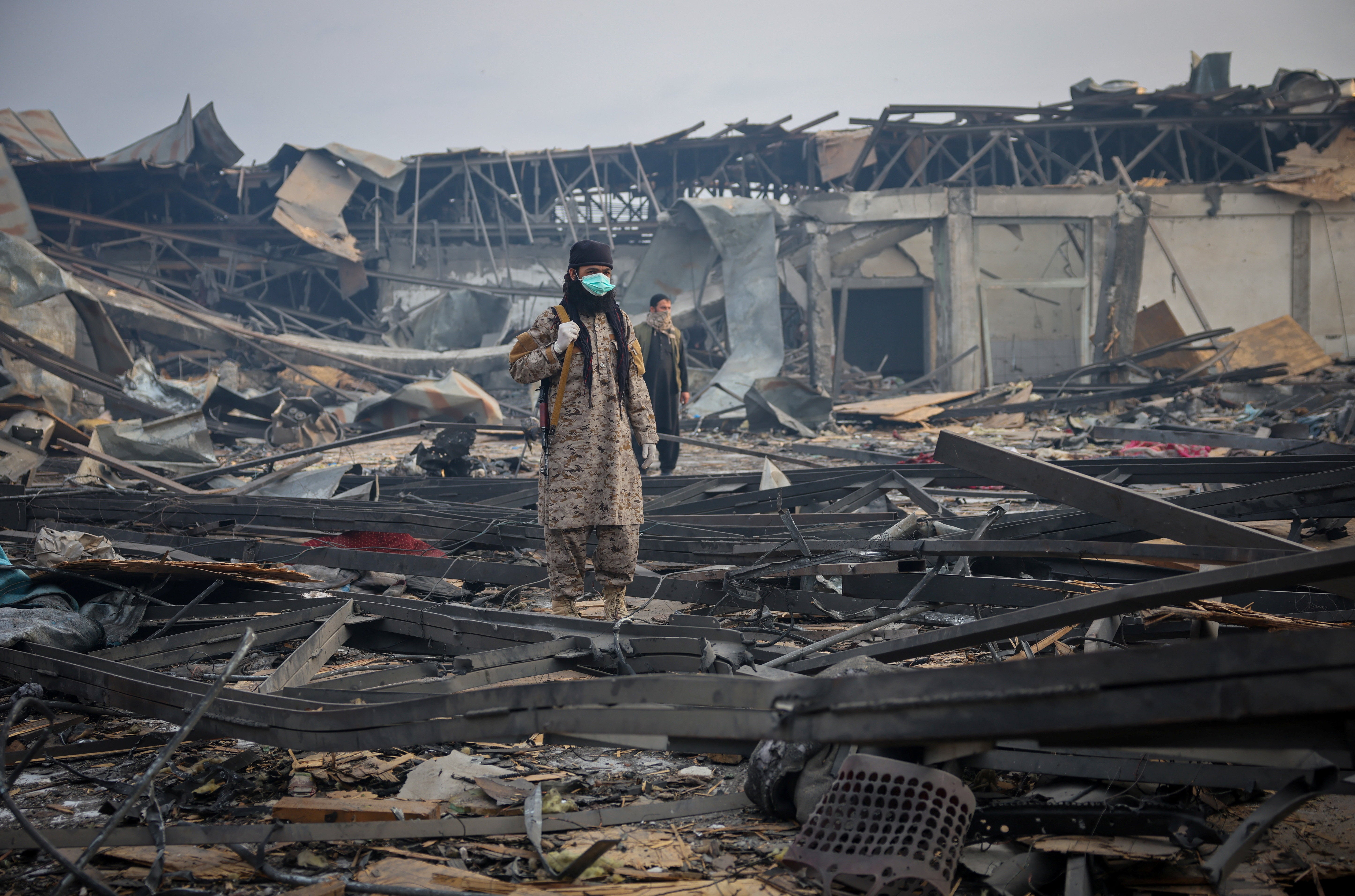 A Taliban soldier walks through debris lying at the site of a drug users rehabilitation hospital destroyed in what the Taliban said was a Pakistani air strike in Kabul, Afghanistan