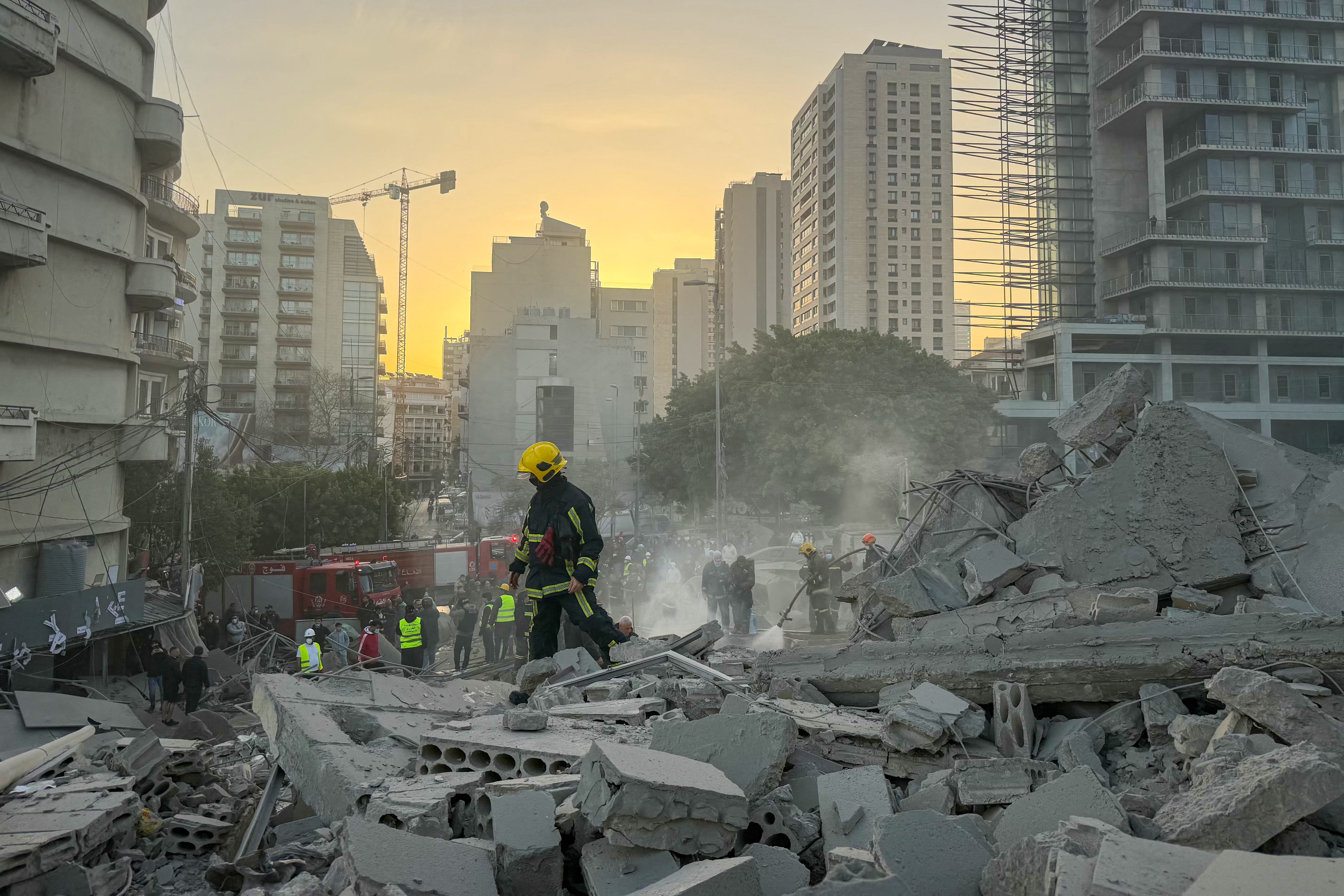 A firefighter walks past rubble at the site of an Israeli airstrike in Beirut's Bashoura neighborhood on March 18