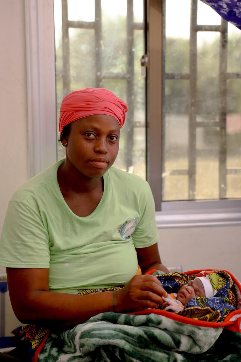 Miatta Kromah holding the hand of her baby girl after delivering her at Diah Clinic, Grand Cape Mount, Liberia