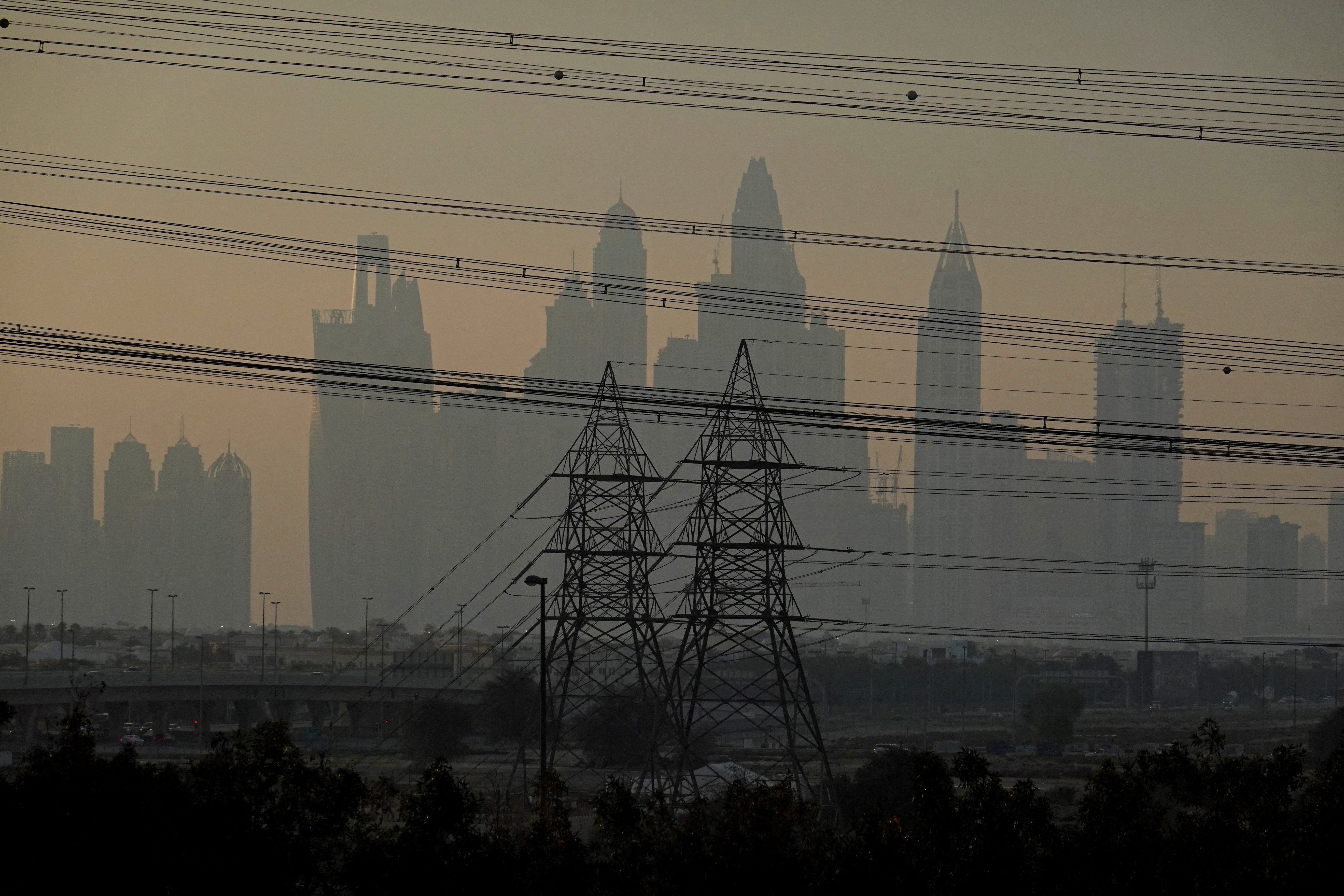 Power towers and cables with the Dubai skyline in the background, amid the US-Israel conflict with Iran, in Dubai, United Arab Emirates