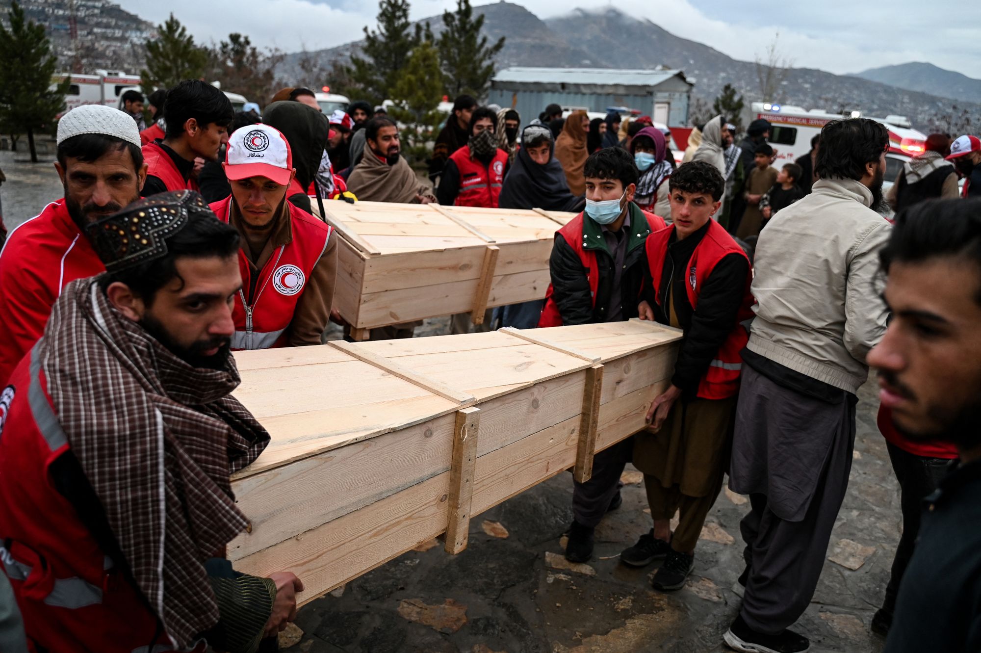 Afghan Red Crescent Society volunteers carry coffins of the victims of a Pakistani airstrike on a drug rehabilitation centre in Kabul