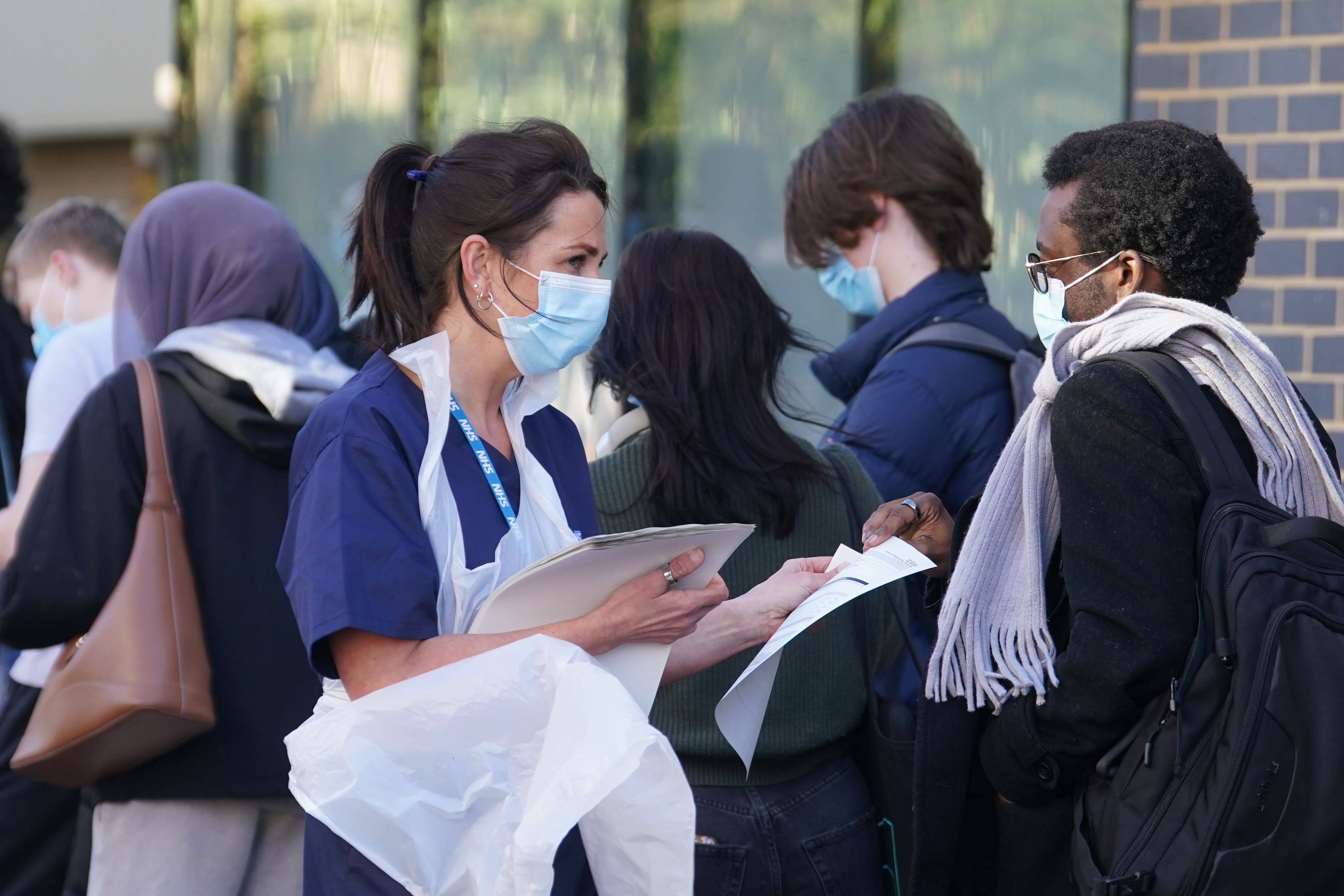 Students wait in line at the entrance to the sports hall at University of Kent campus in Canterbury