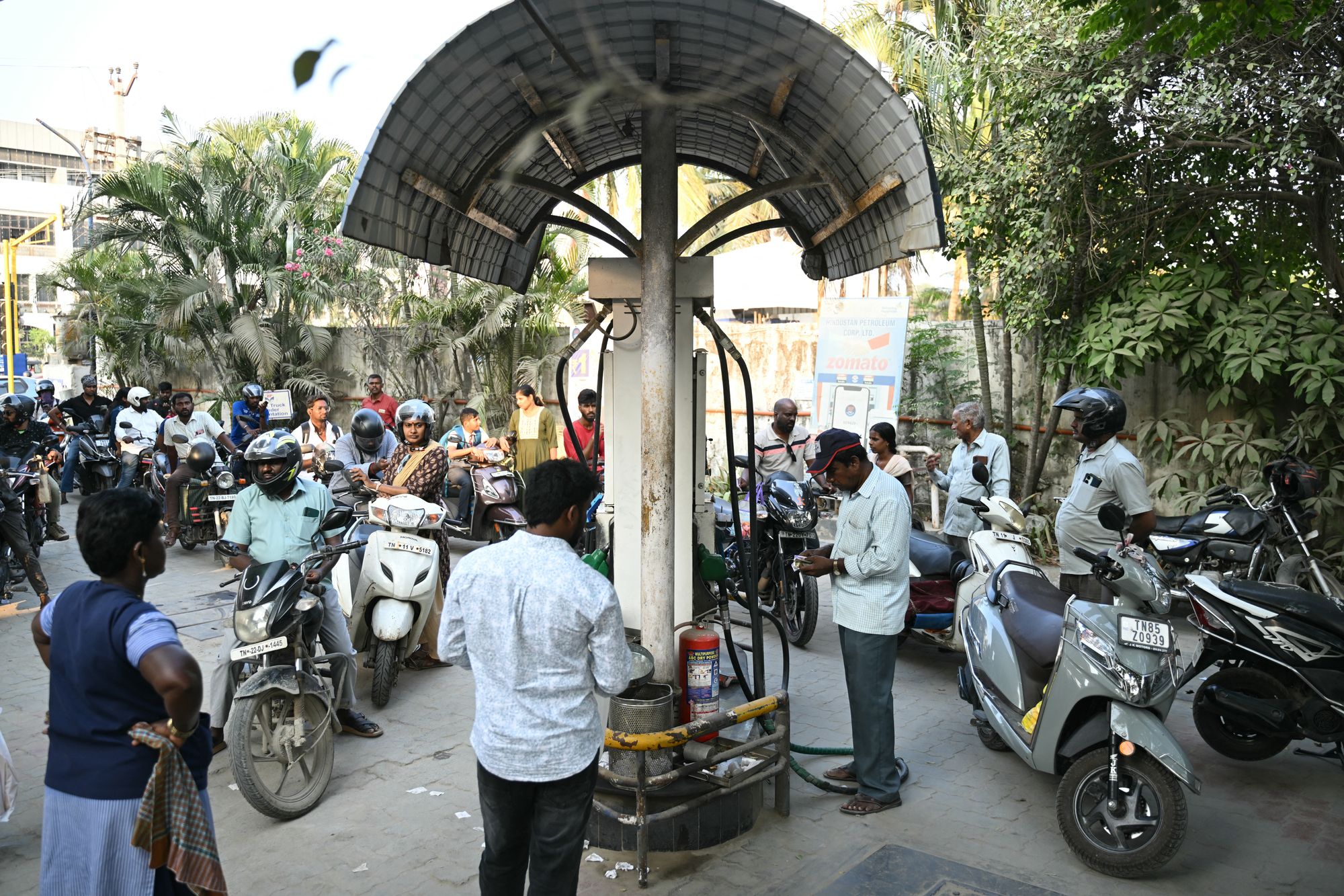 People queue up to refuel their vehicles at a gas station in Chennai