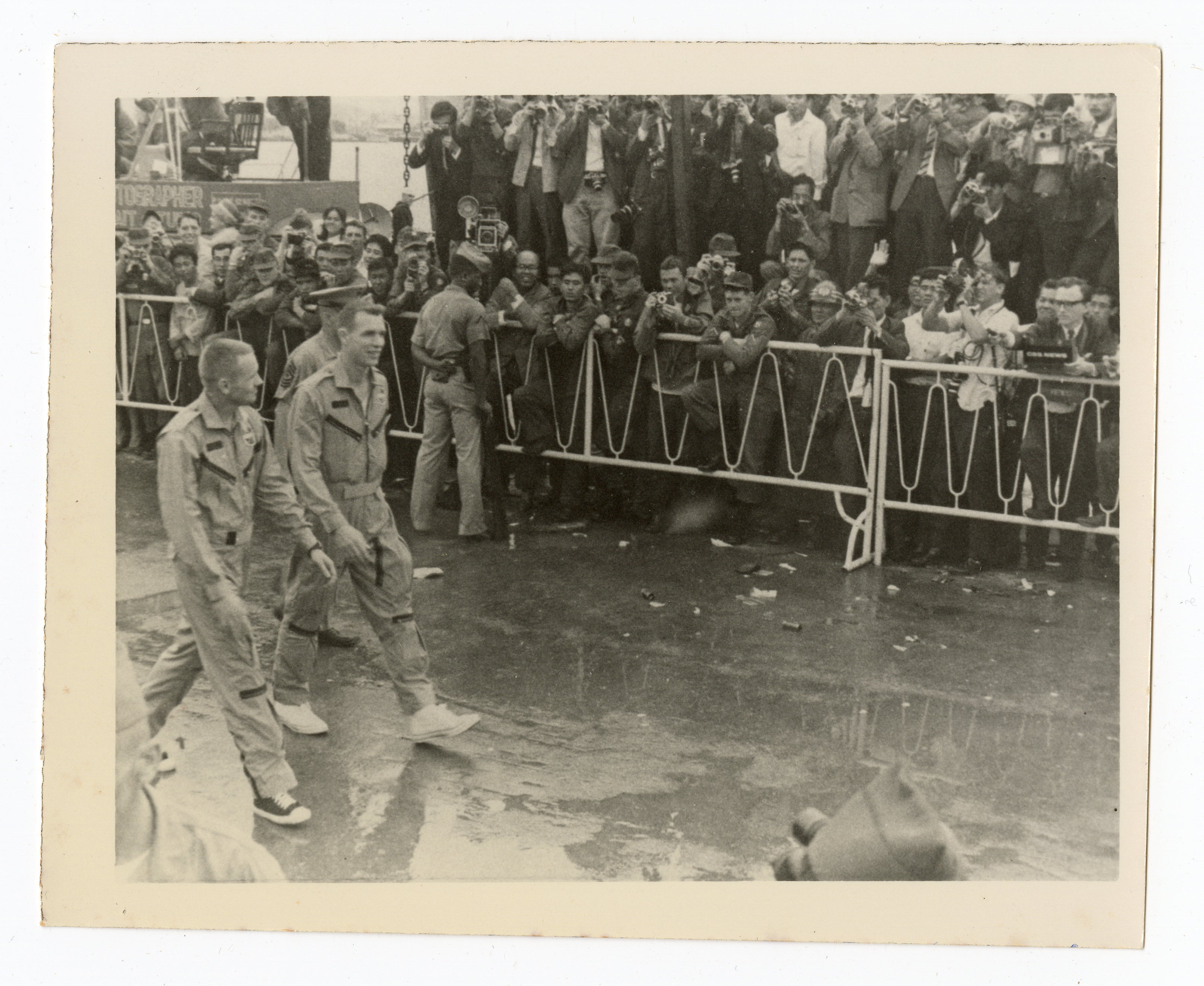 Neil Armstrong (left) and David Scott walking through a crowd of U.S. service members at Naha Air Base in Okinawa, Japan in 1966