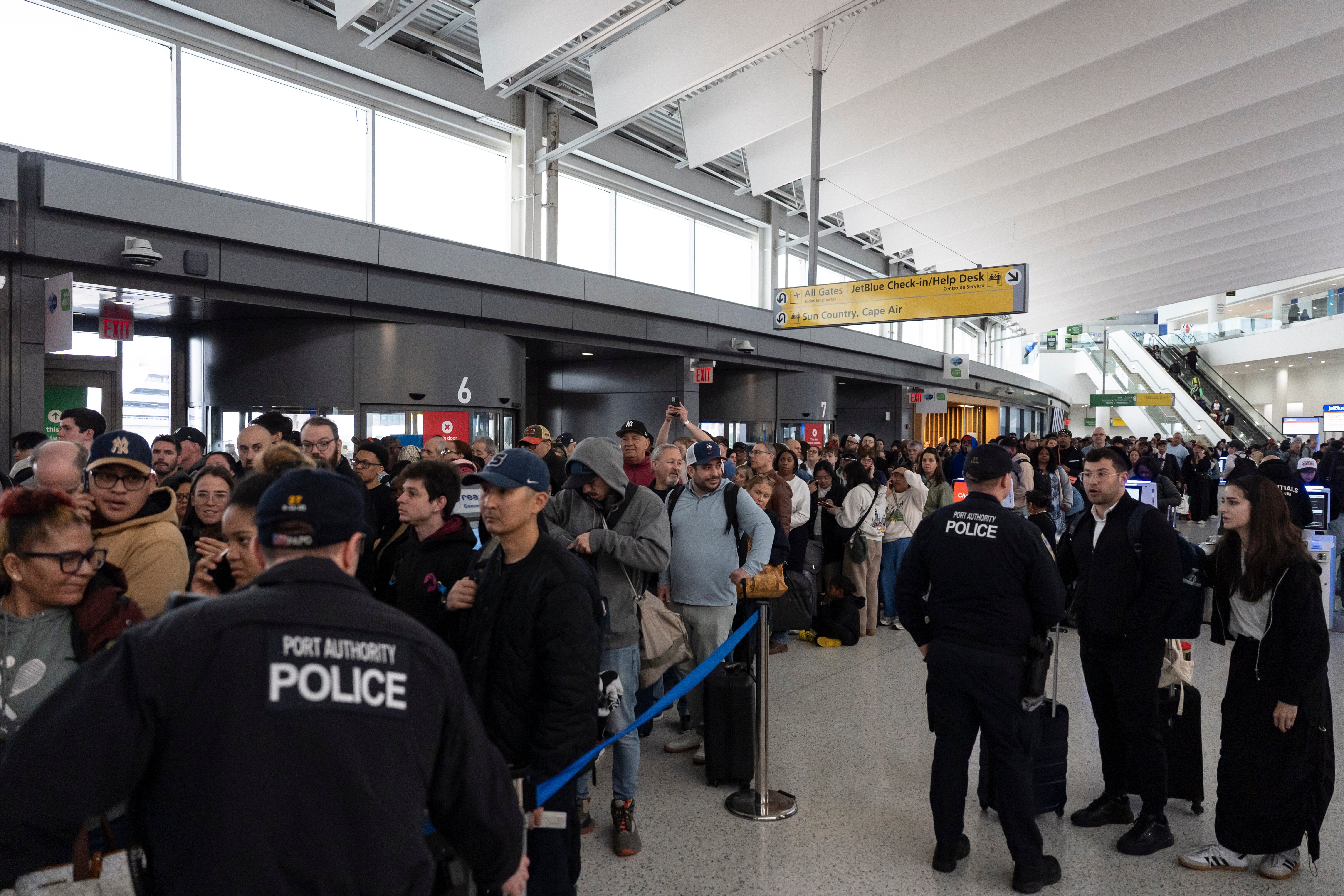 People wait in a TSA line at the John F. Kennedy International Airport, Sunday, March 22