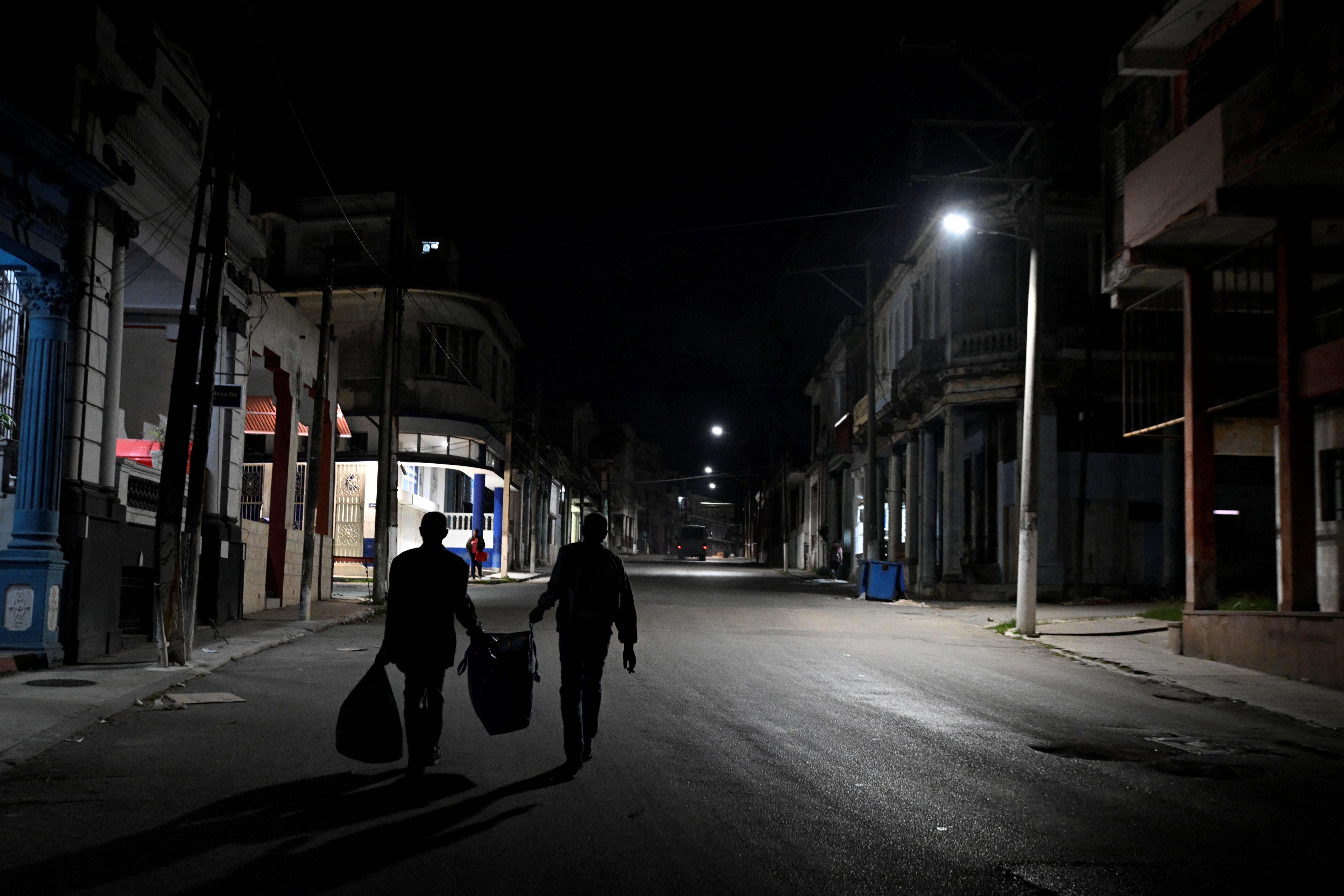 People walk in Havana as Cuba begins efforts to restore power after its grid collapsed for the second time in a week