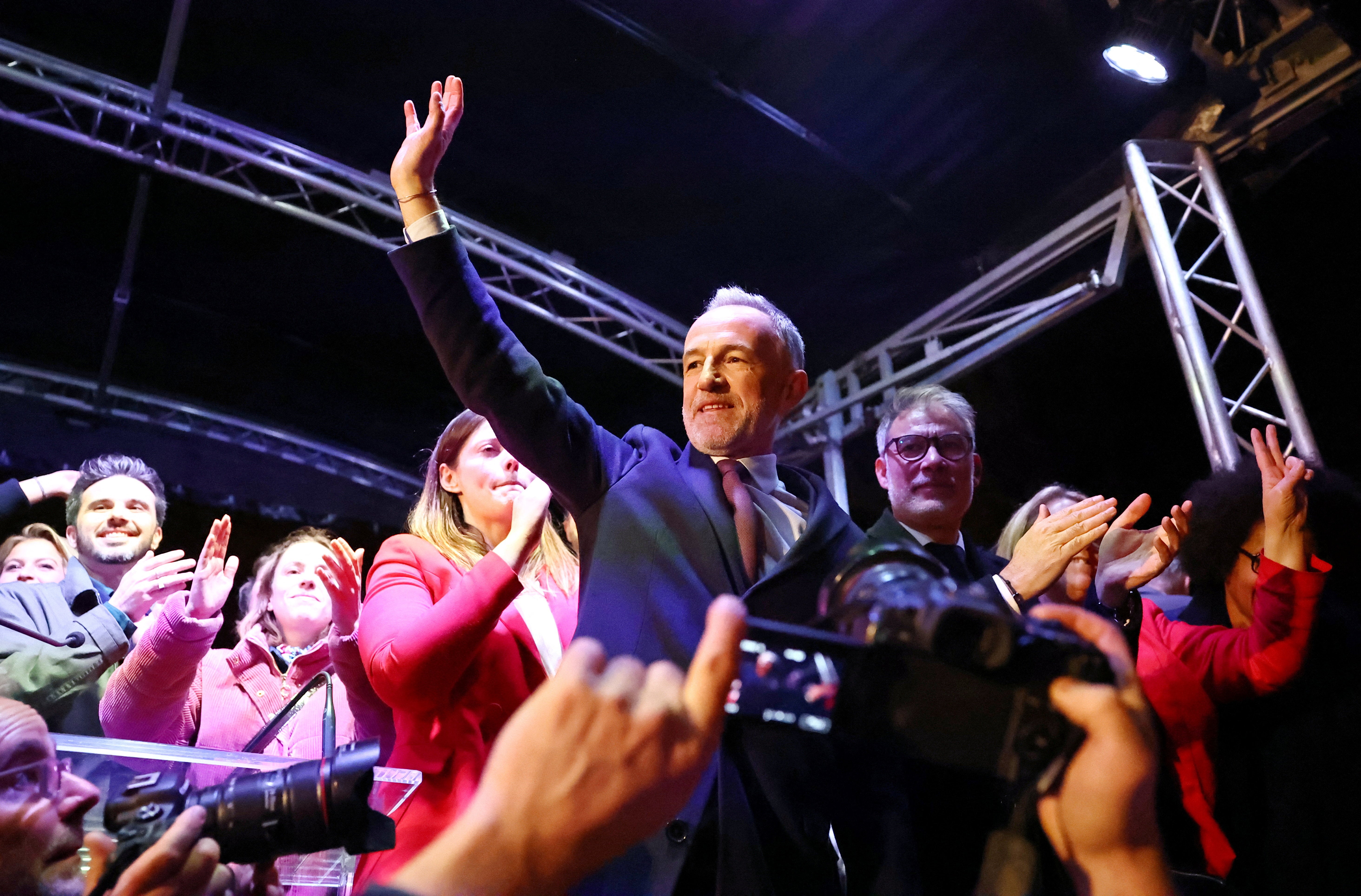Emmanuel Gregoire reacts next to Olivier Faure, first secretary of the French Socialist Party, as they stand on a stage in front of the Paris City Hall after early results suggested he had won the second round of the mayoral election in Paris