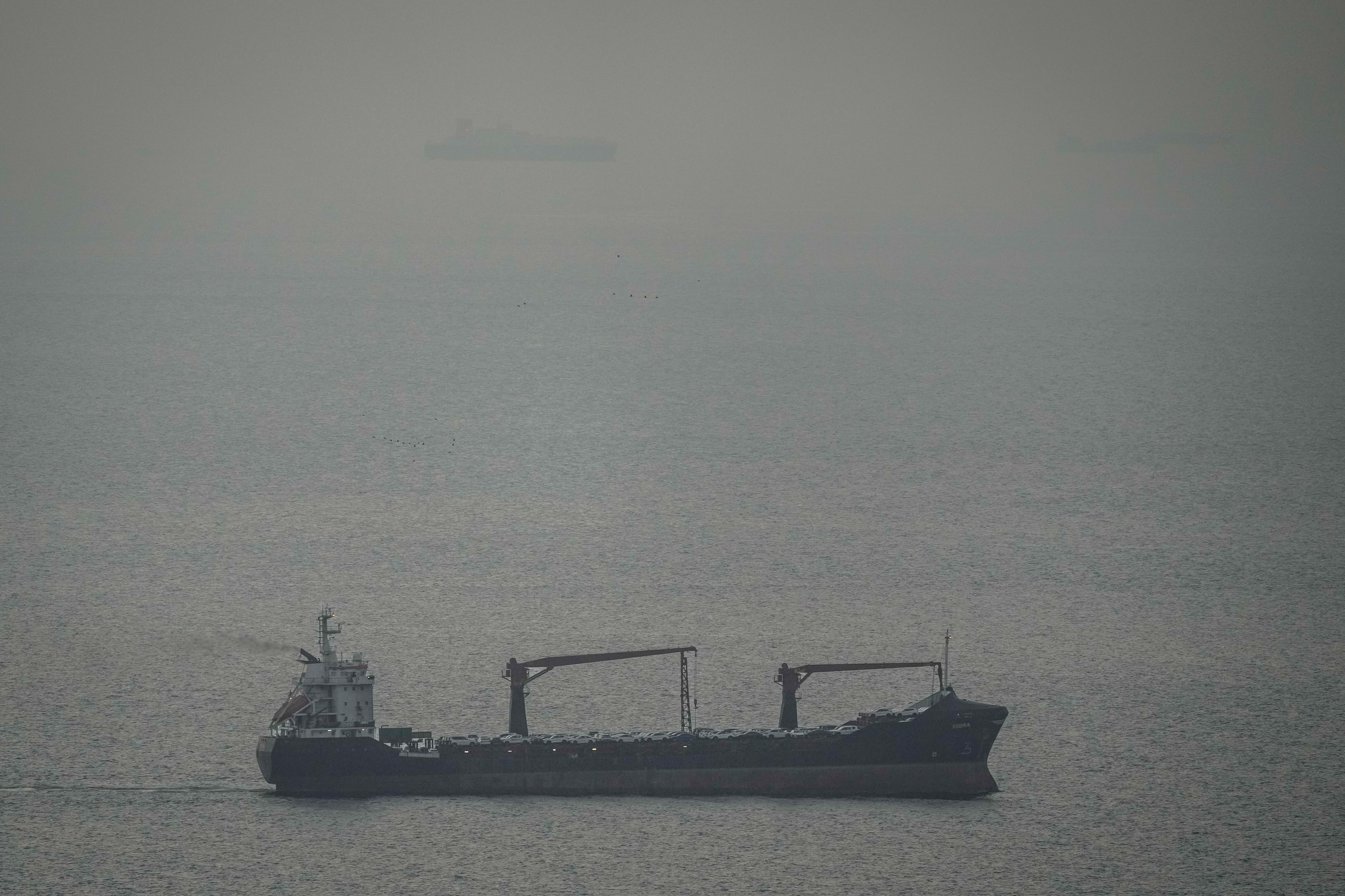 A cargo ship carrying vehicles is heading from the Persian Gulf to the Strait of Hormuz