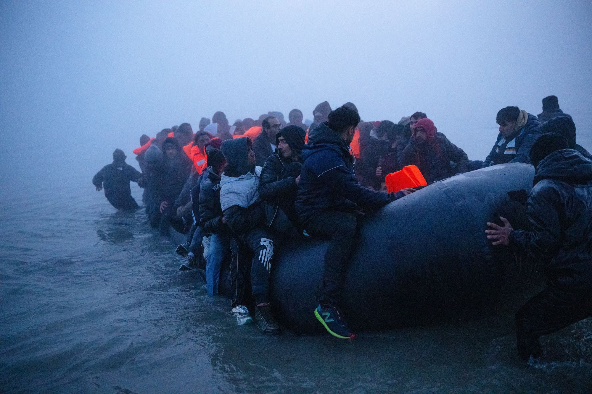 Migrants sit aboard a dinghy as they prepare to sail into the English Channel on 4 March in Gravelines, France