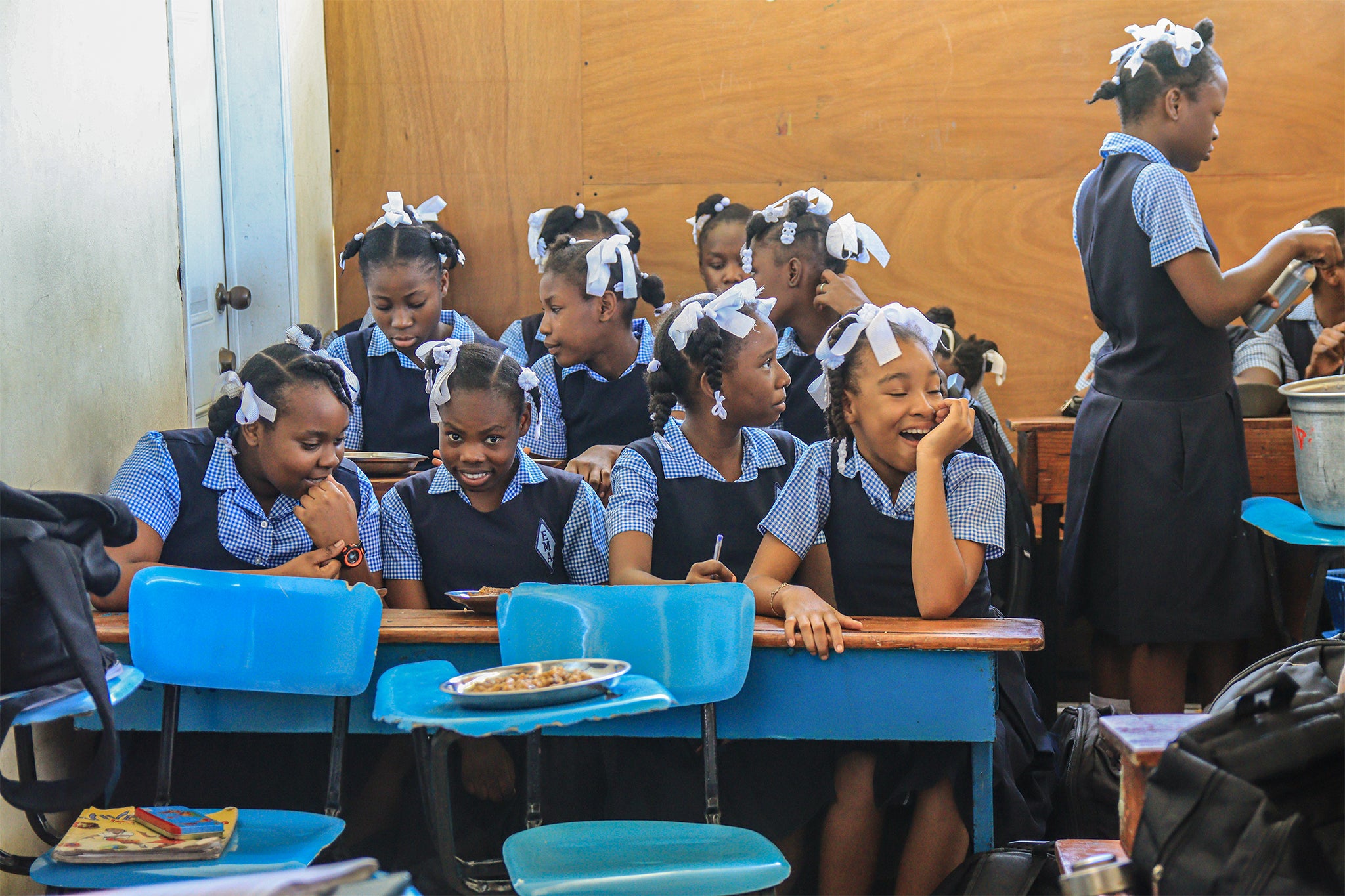 Girls eat their food and prepare for classes in Haiti, undated