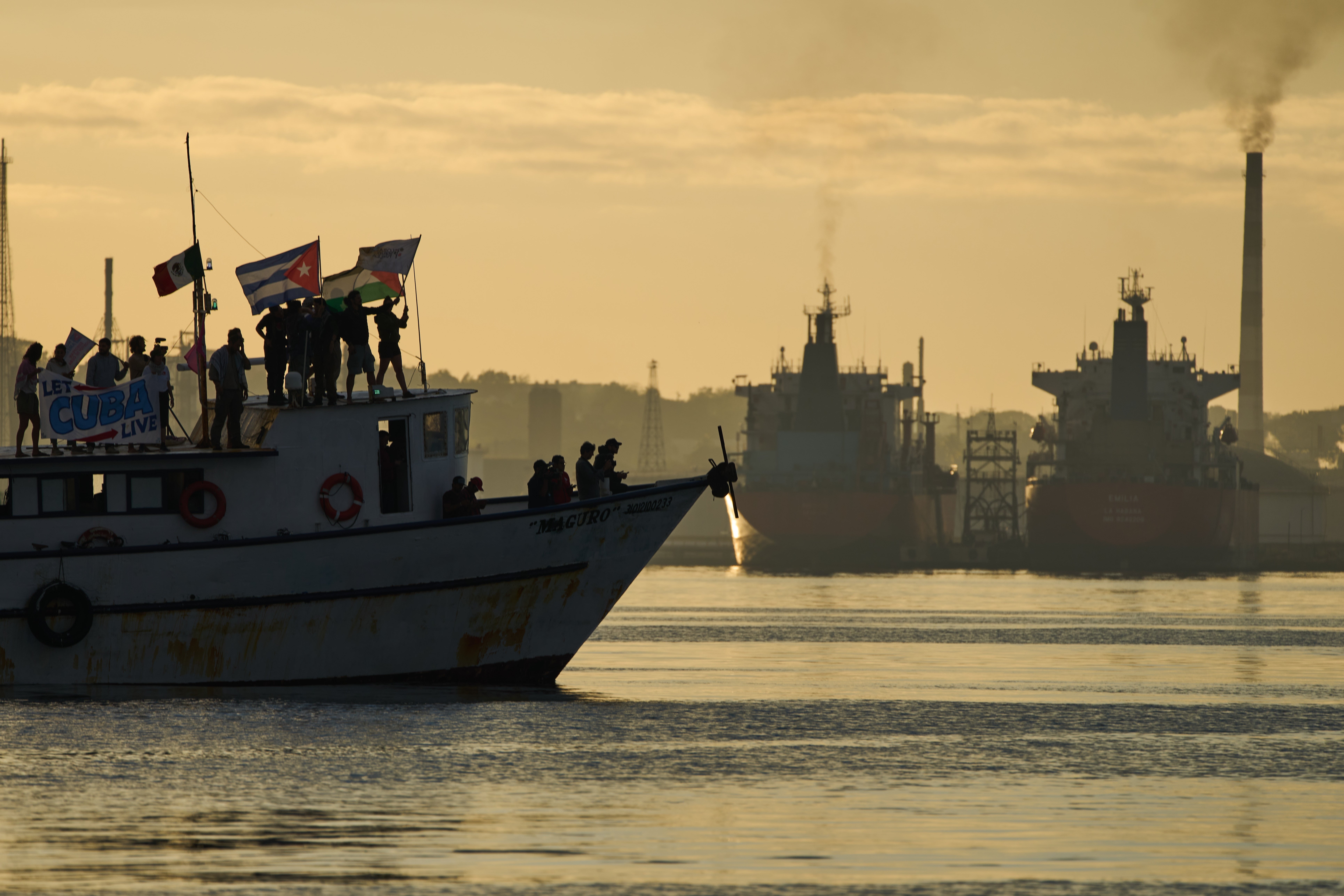 Activists wave Cuban and Palestinian flags from the vessel Maguro, arriving from Mexico with humanitarian aid as part of the 