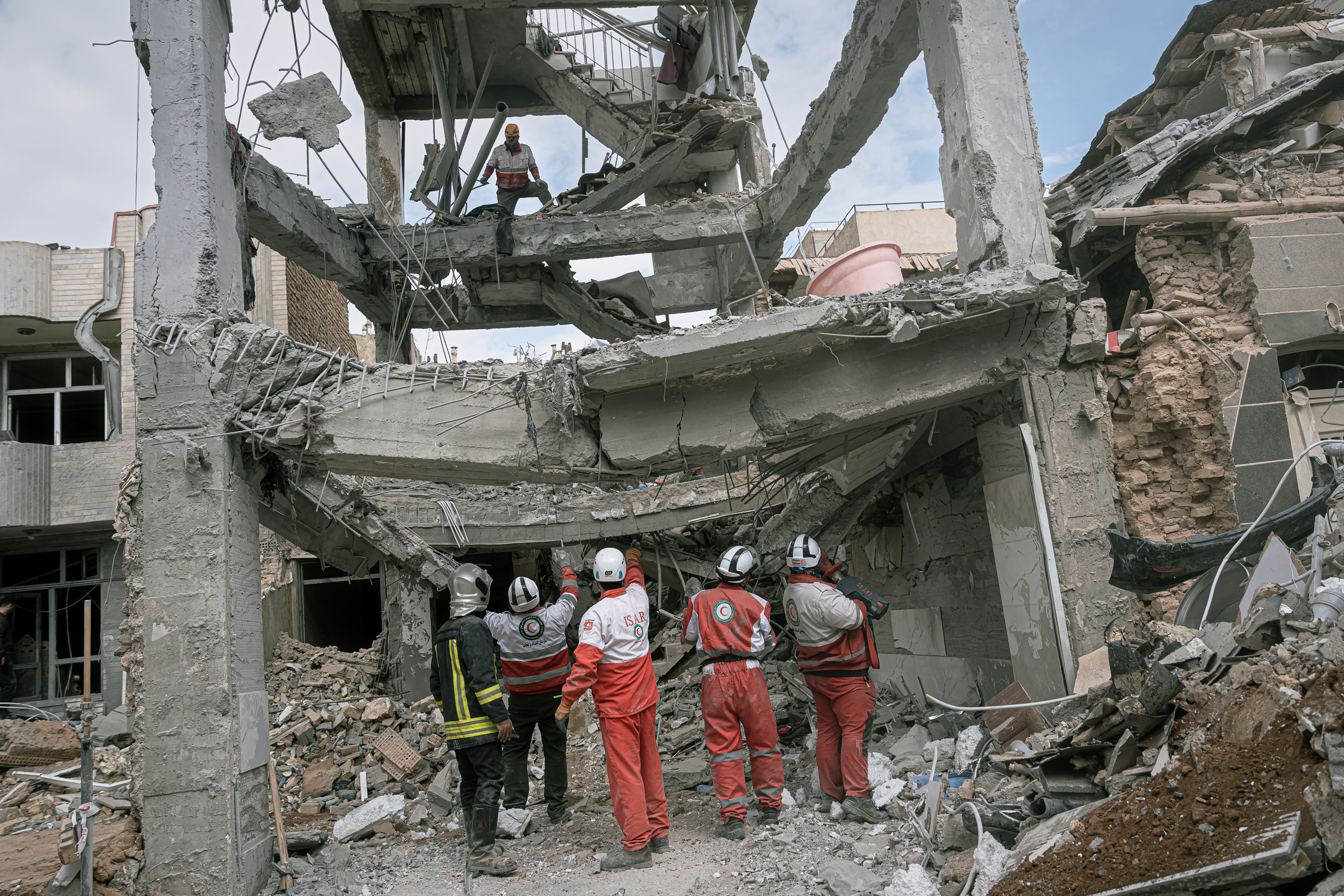 First responders examine the remains of a residential building hit in an overnight attack in Iran on Tuesday