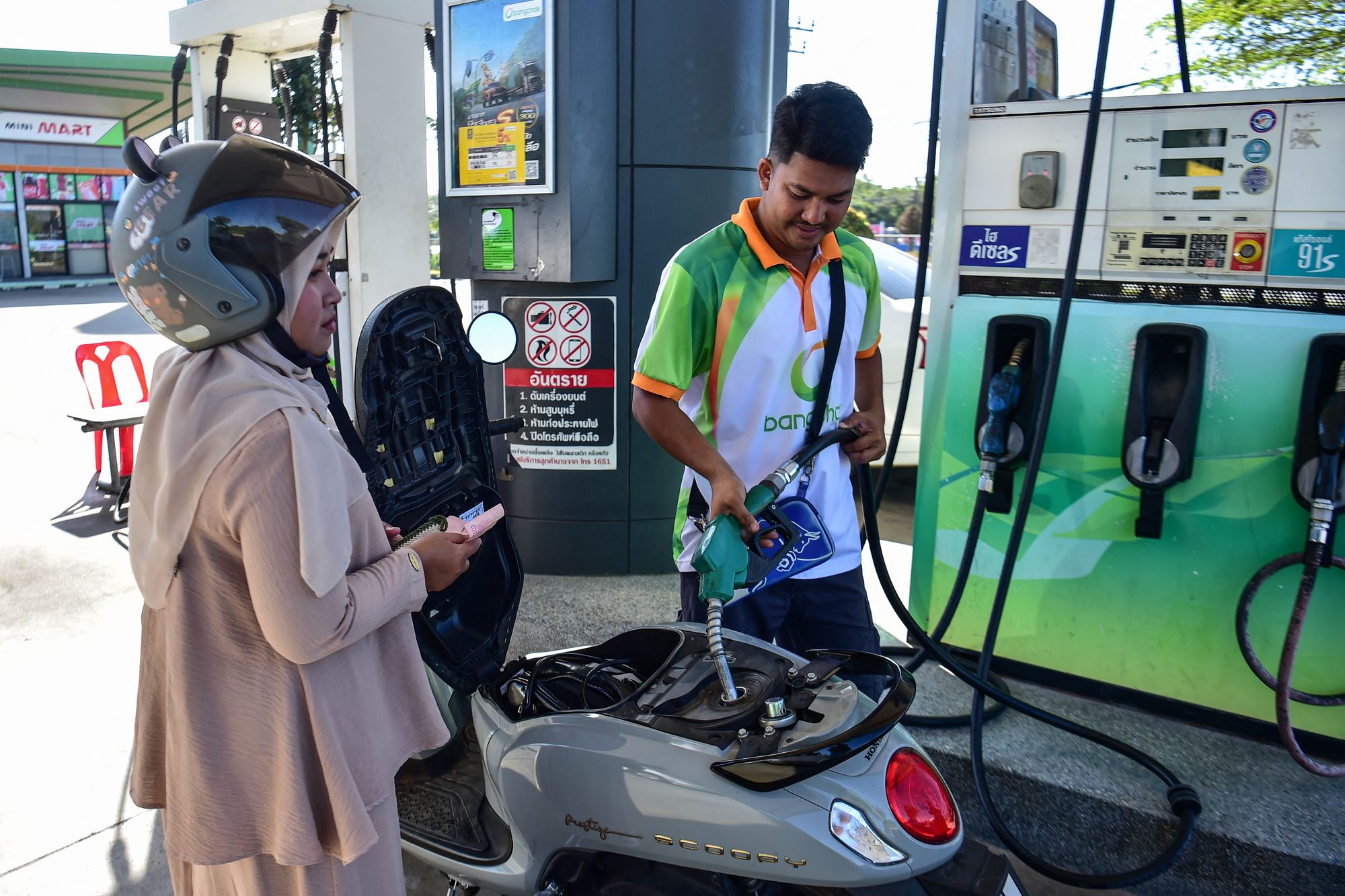 An employee refuels a vehicle at a petrol station in the southern Thai province of Narathiwat on March 18, 2026