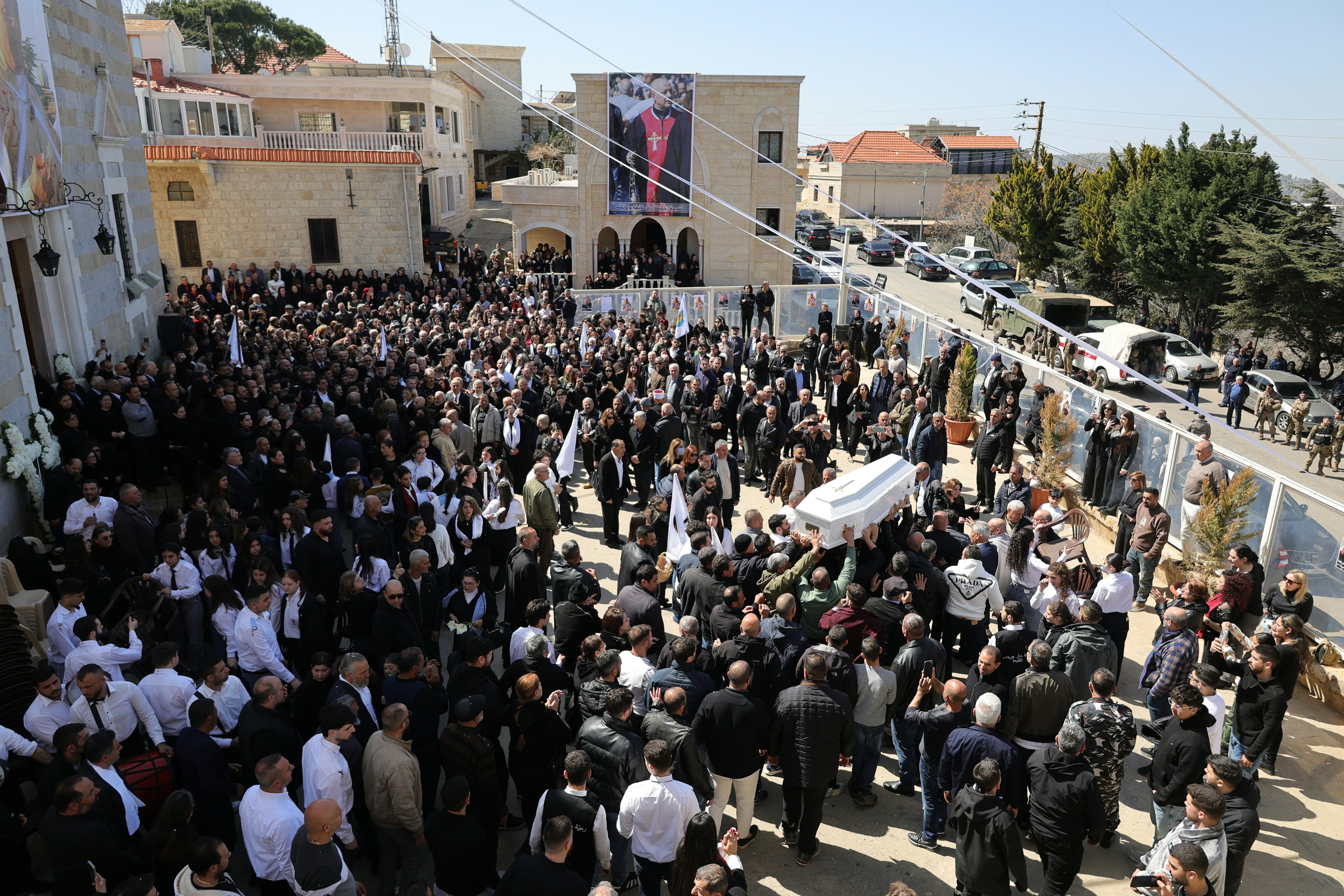 Residents of the Christian Lebanese border village of Qlayaa carry the coffin of the village's priest
