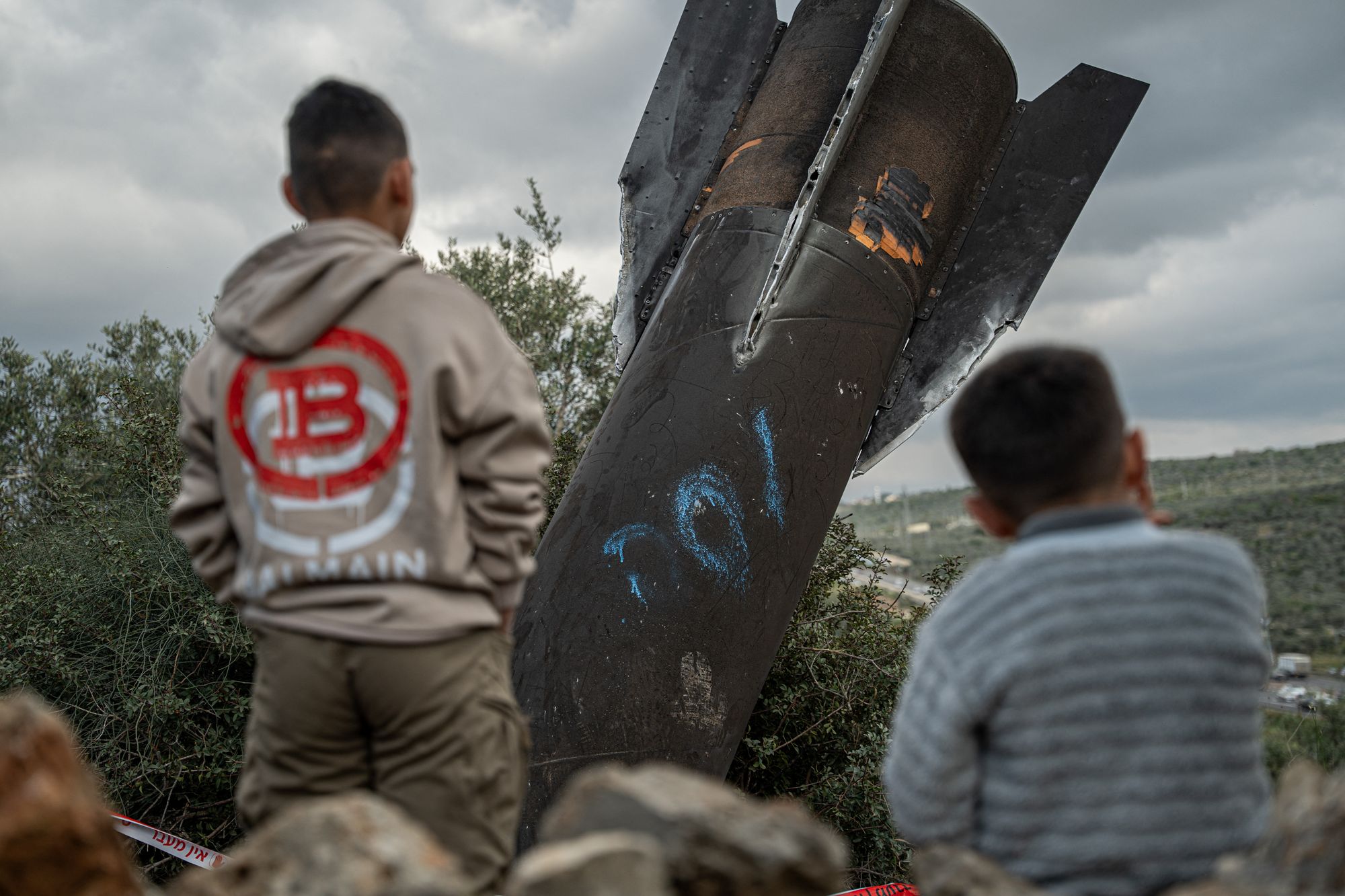 Palestinian boys gather around the remnants of an Iranian missile that landed in the Palestinian village of Hares in the Israeli-occupied West Bank on March 24, 2026